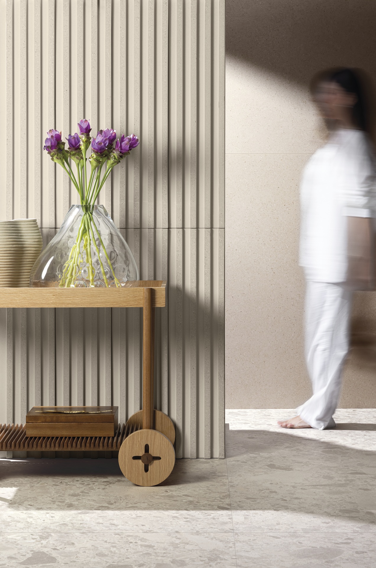 Parede frisada com produto Pietra Lombarda, com aparador de madeira em frente