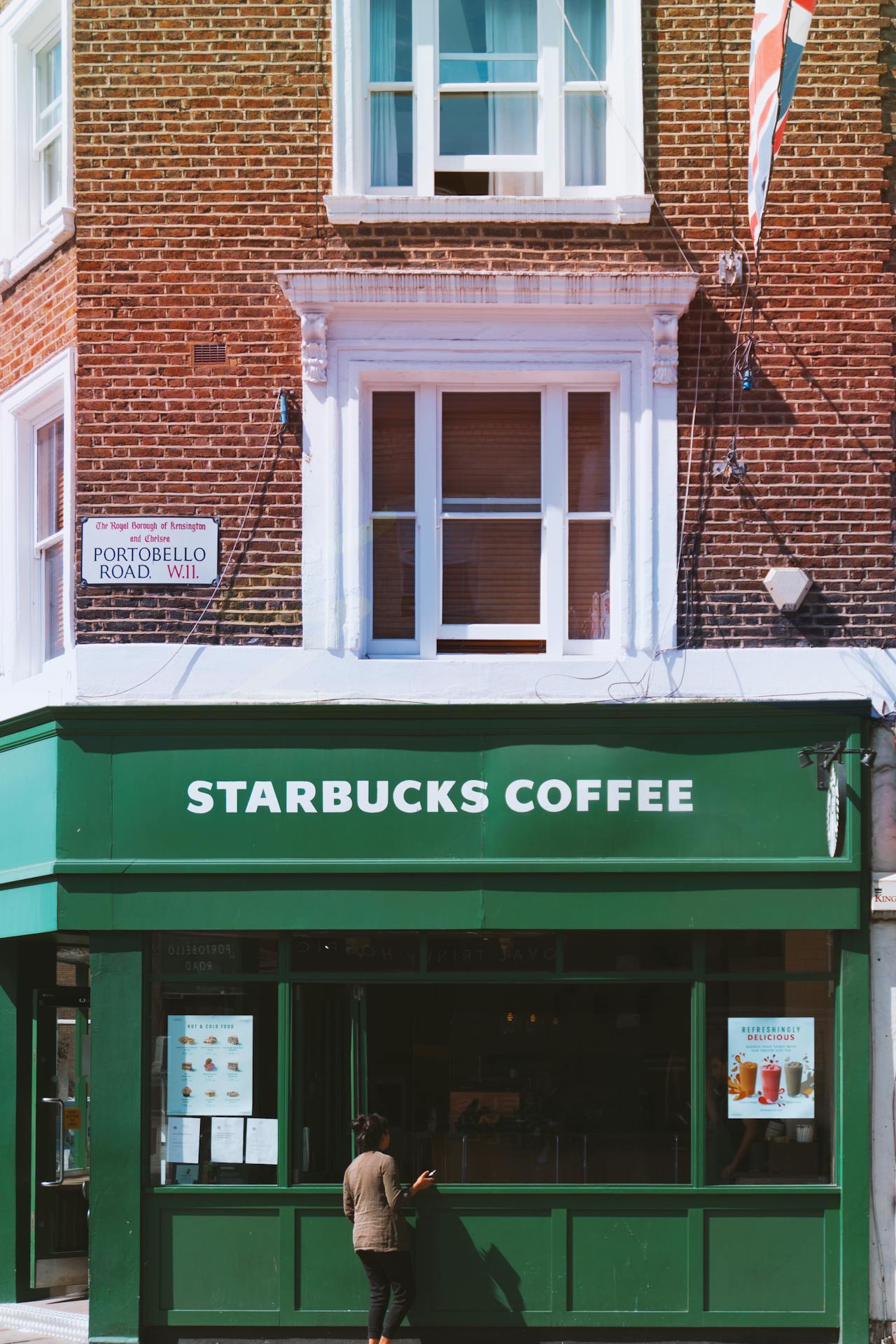 Fachada de tijolos com janelas brancas salientes em estilo vitoriano sobre uma loja da Starbucks, na Portobello Road
