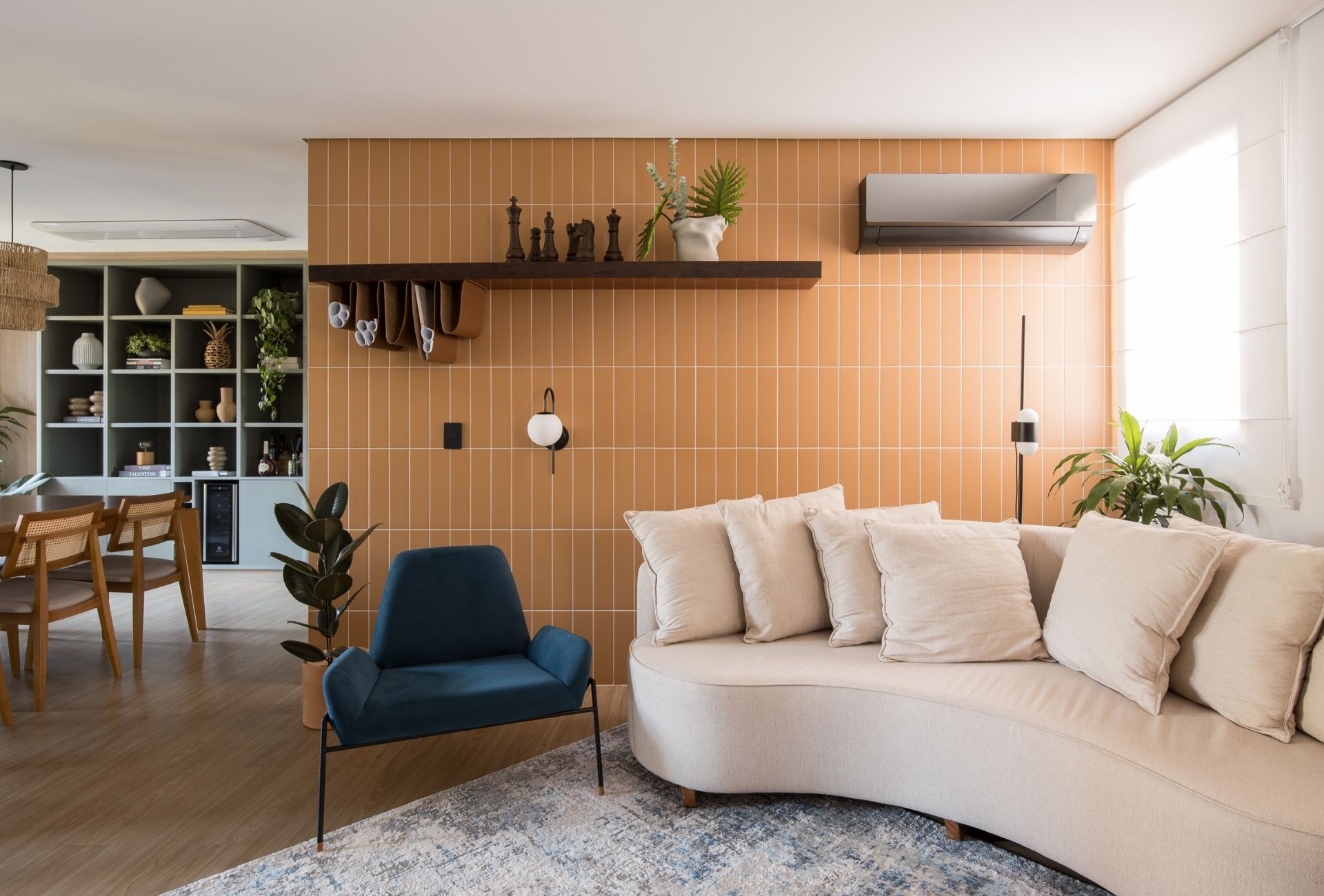 Cadeira na cor azul se destaca na composição de cores da sala de estar