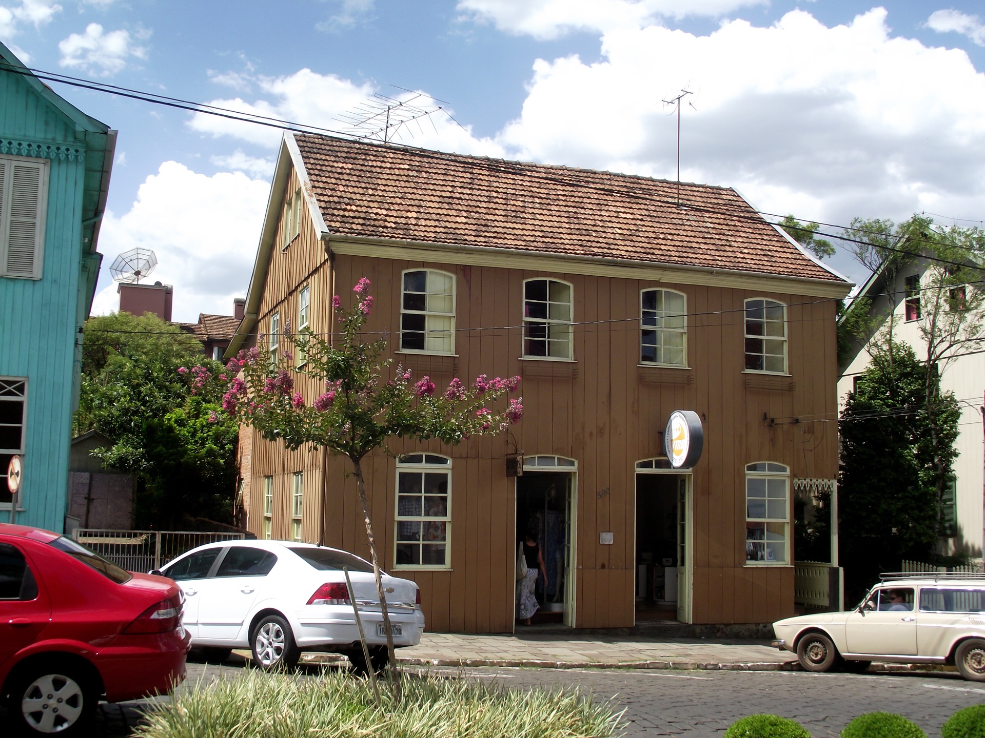 Casa antiga de madeira com telhado de duas águas e janelas em arco, localizada em Antônio Prado, Rio Grande do Sul, representando a herança cultural italiana na região