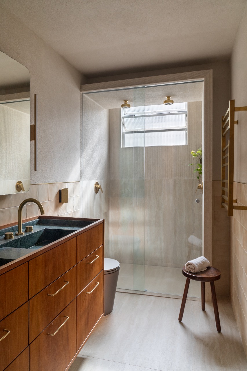 Banheiro com piso e paredes em porcelanato que reproduz travertino