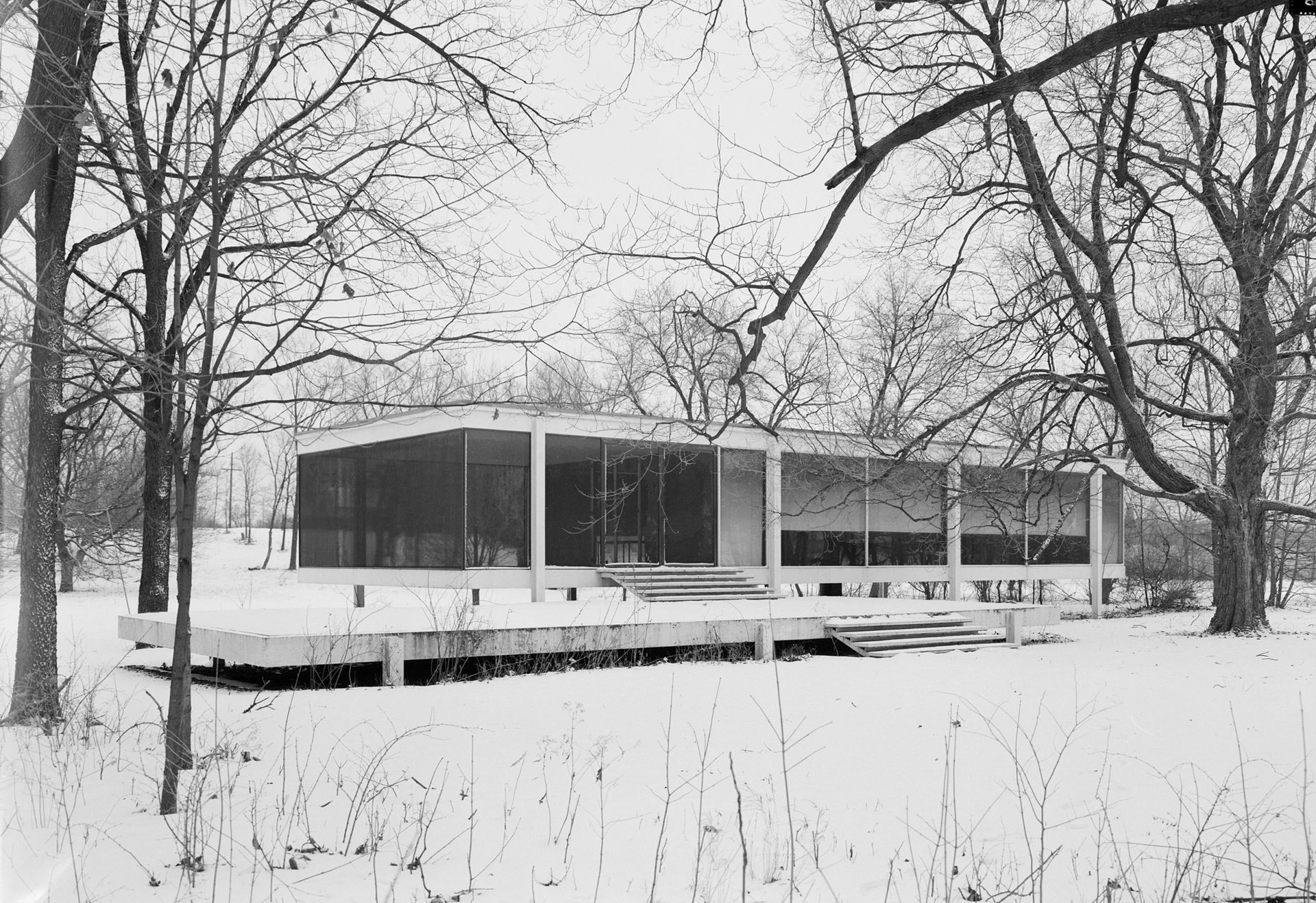 Farnsworth House em 1971, vista no inverno, elevada sobre colunas e cercada por árvores sem folhas