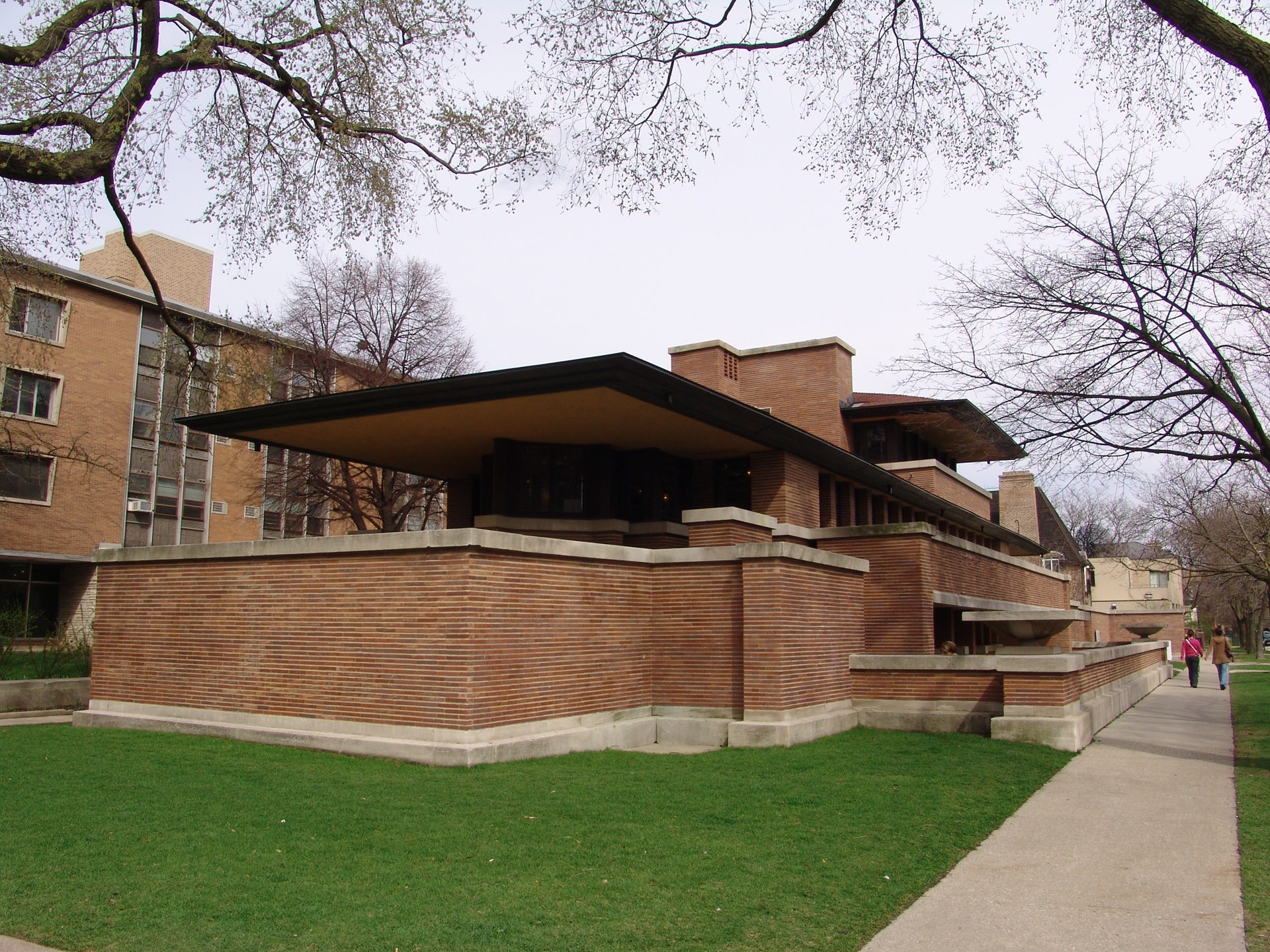 Vista externa da Robie House, em Chicago, projetada por Frank Lloyd Wright em 1909. A imagem mostra a marcante estrutura horizontal, com tijolos aparentes, beirais extensos e volumes interligados