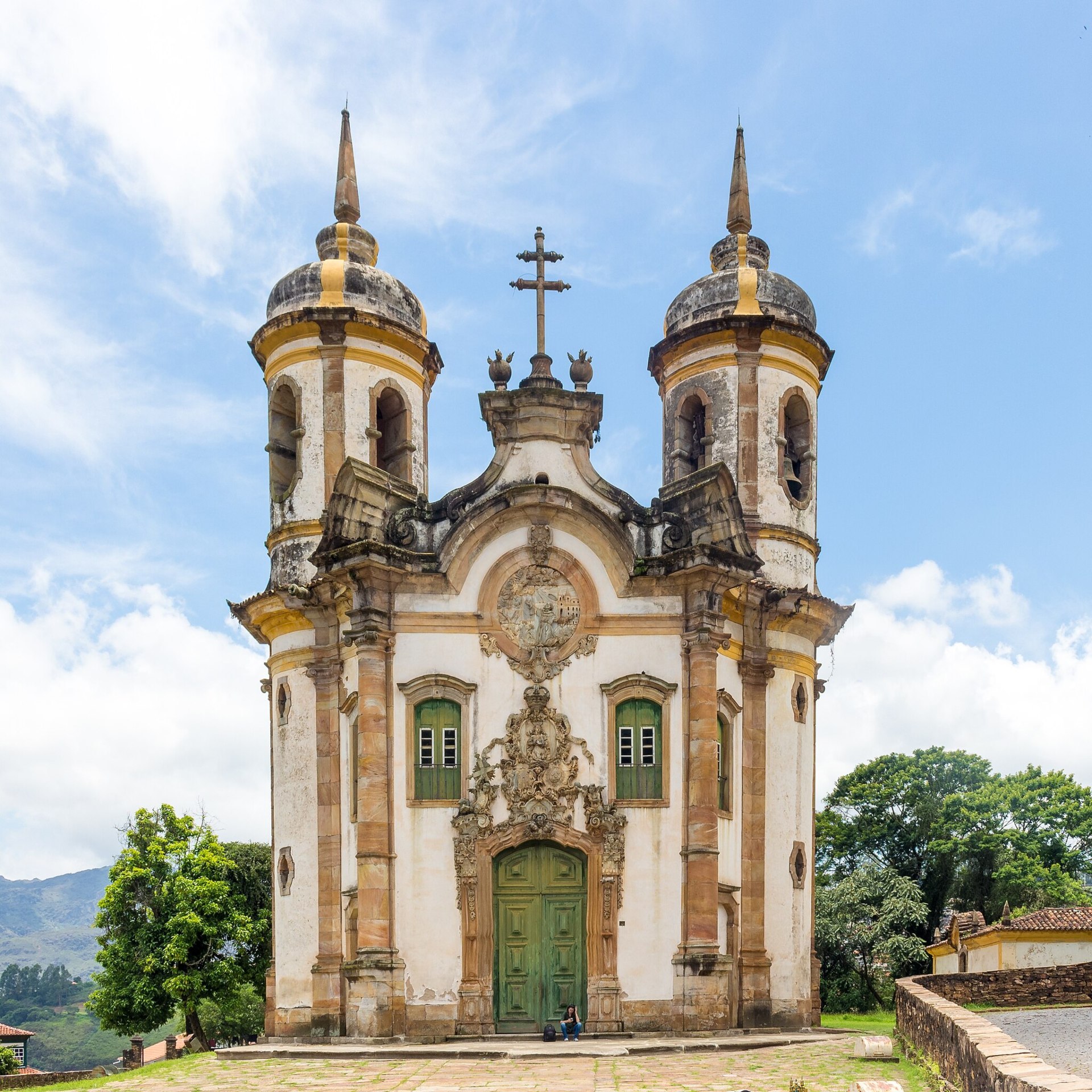 Vista frontal da Igreja de São Francisco de Assis, em Ouro Preto (MG), destacando sua fachada barroca com esculturas em pedra-sabão e elementos decorativos. A imagem captura a imponência da igreja, situada no Largo de Coimbra, no centro histórico da cidade
