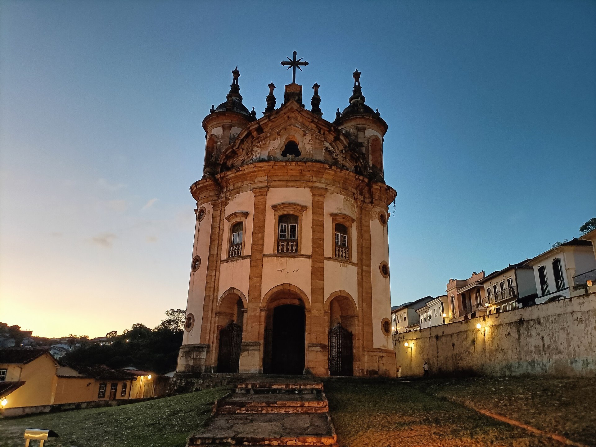 Vista frontal da Igreja de Nossa Senhora do Rosário dos Homens Pretos, em Ouro Preto (MG), destacando sua fachada barroca com três arcos e portas sacadas. O edifício, tombado pelo Iphan, reflete a arquitetura colonial mineira e a história da resistência negra na região