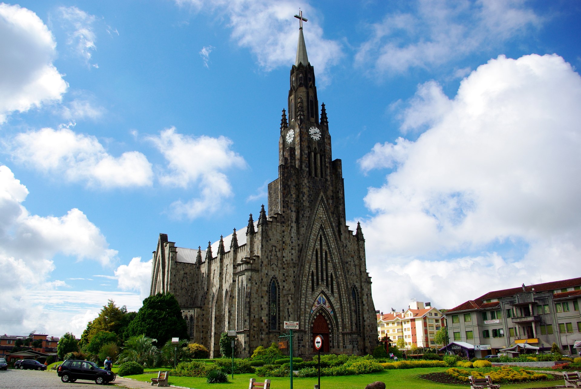 Vista frontal da Igreja Matriz Nossa Senhora de Lourdes, em Canela (RS), destacando sua fachada em pedra basalto e arquitetura neogótica. O edifício é um importante ponto turístico e religioso da cidade