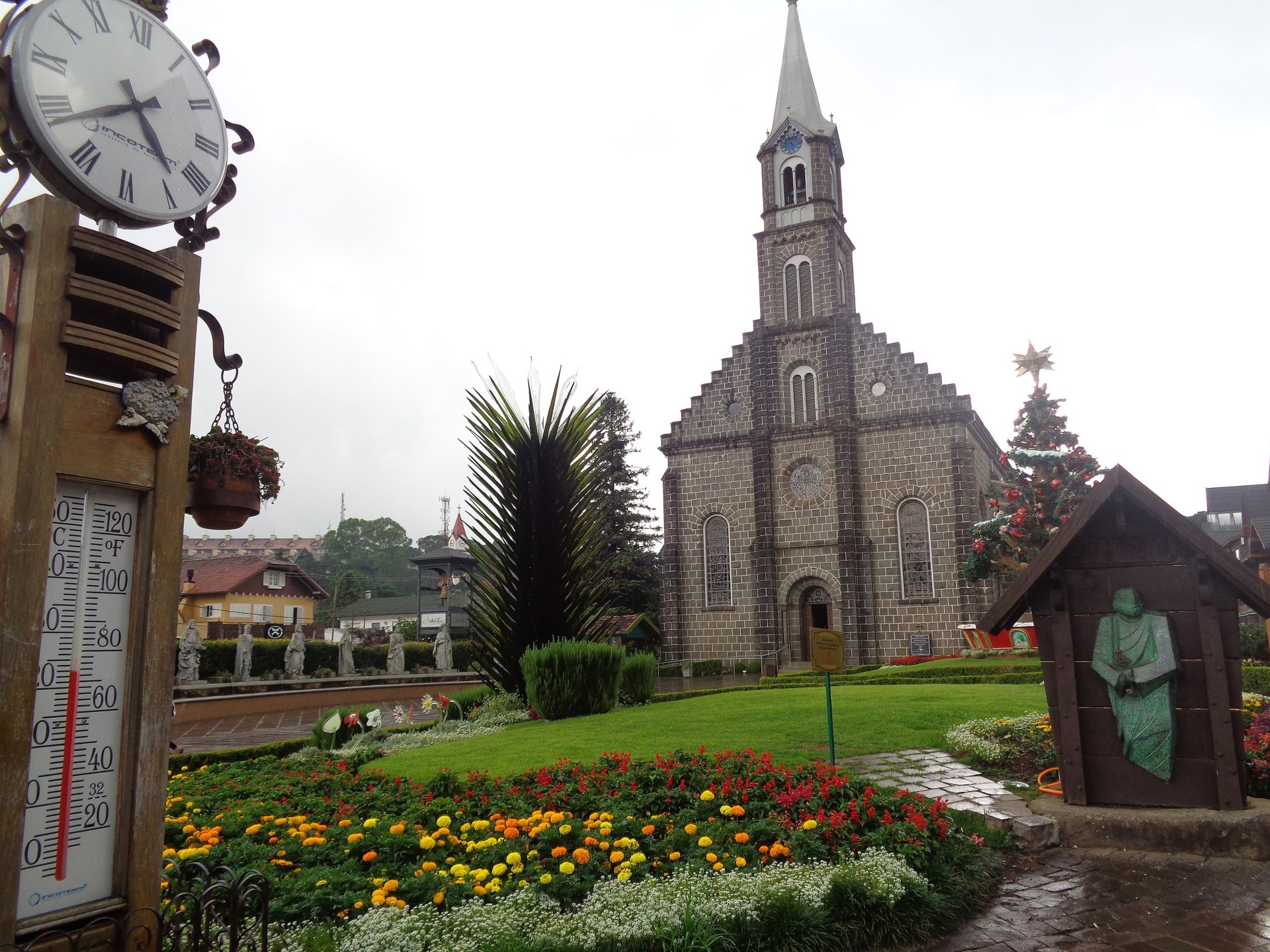 Vista panorâmica da cidade de Gramado (RS), destacando a arquitetura típica europeia com casas e prédios de telhados inclinados e fachadas coloridas, cercados por áreas verdes e árvores