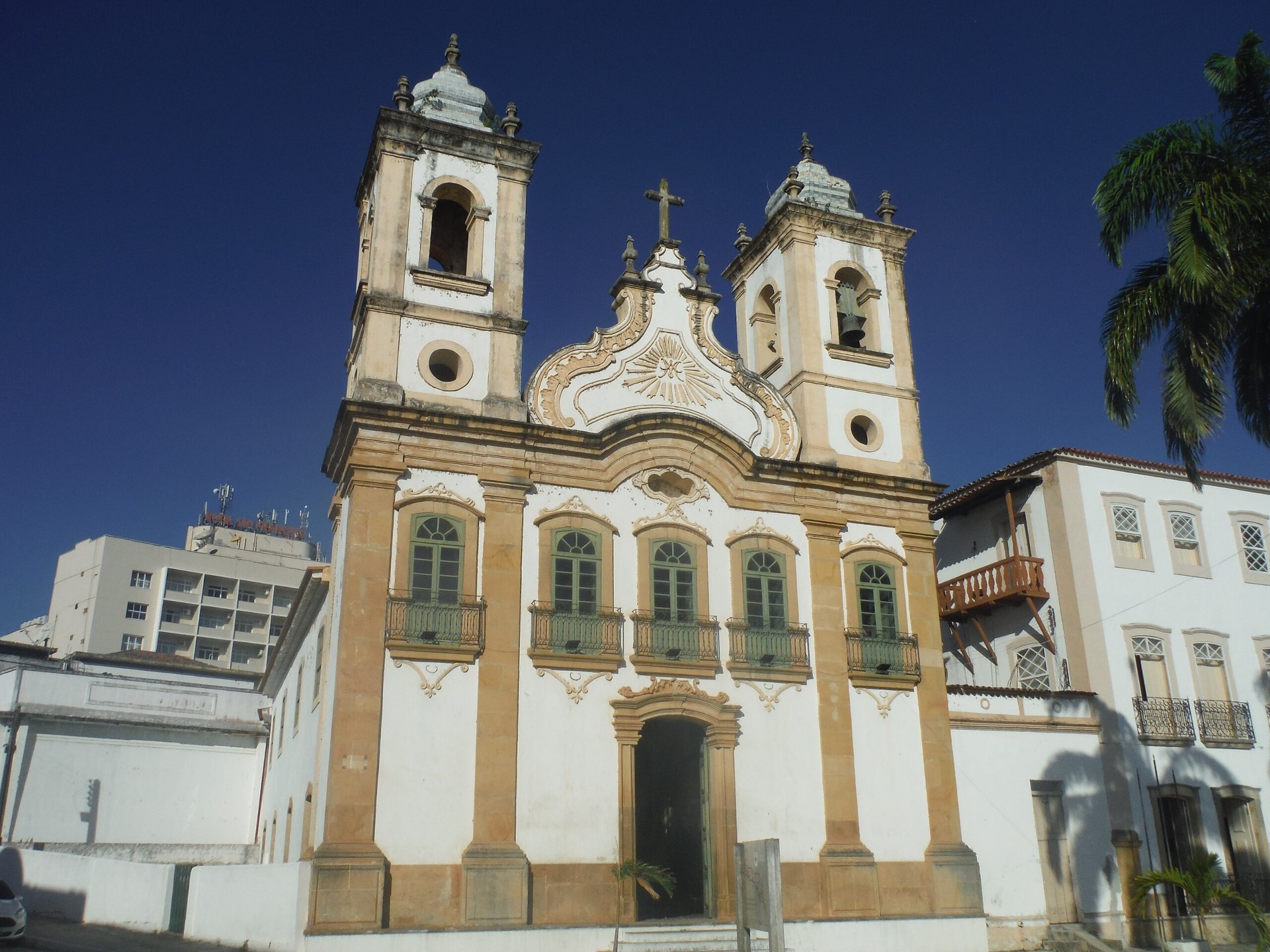 Fachada da Igreja de Nossa Senhora da Corrente, em Penedo (AL): templo católico antigo com duas torres, portal central moldado em estilo barroco/rococó e detalhes neoclássicos; revestida parcialmente por azulejos portugueses coloridos e piso de cerâmica inglesa, transmitindo riqueza decorativa e tradição histórica