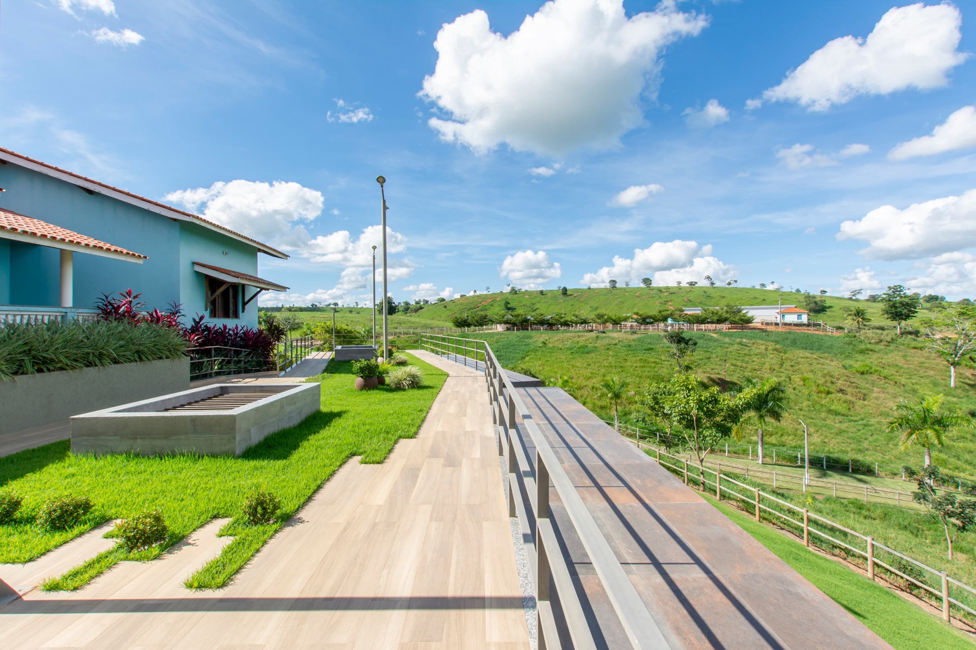 Área externa com piso amadeirado e visão para área verde