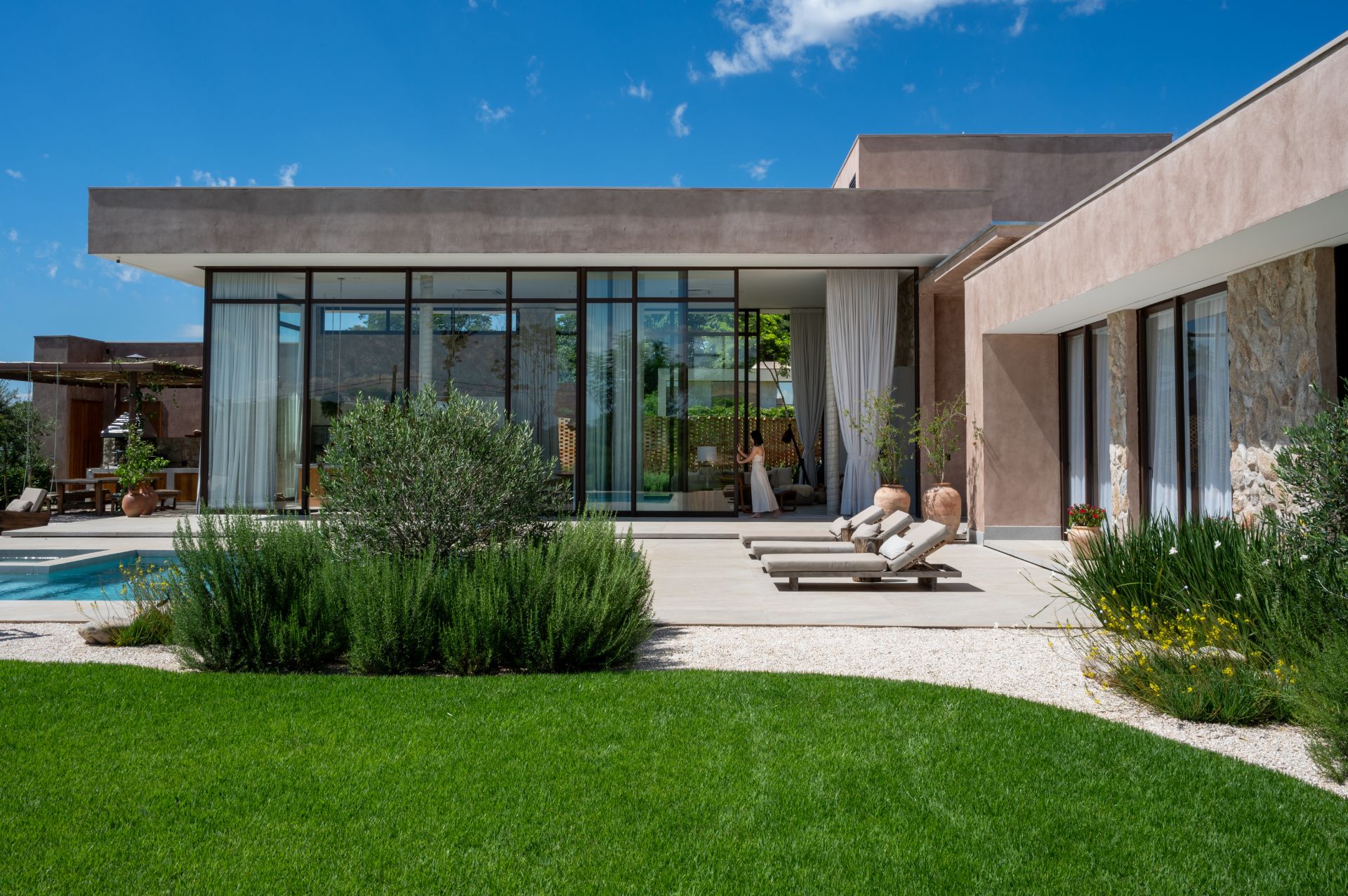 Casa em estilo mediterrãneo com jardim e área externa com espreguiçadeiras