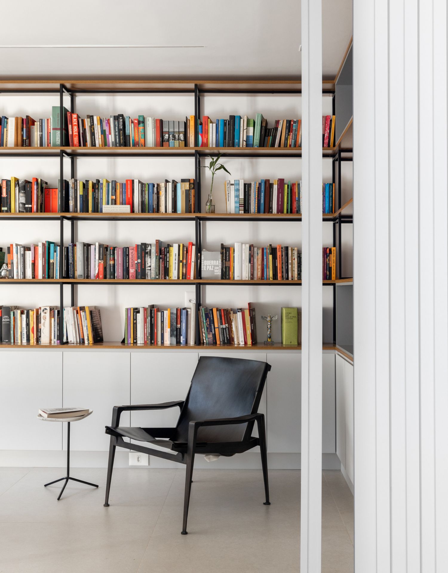 Poltrona preta minimalista utilizada em biblioteca