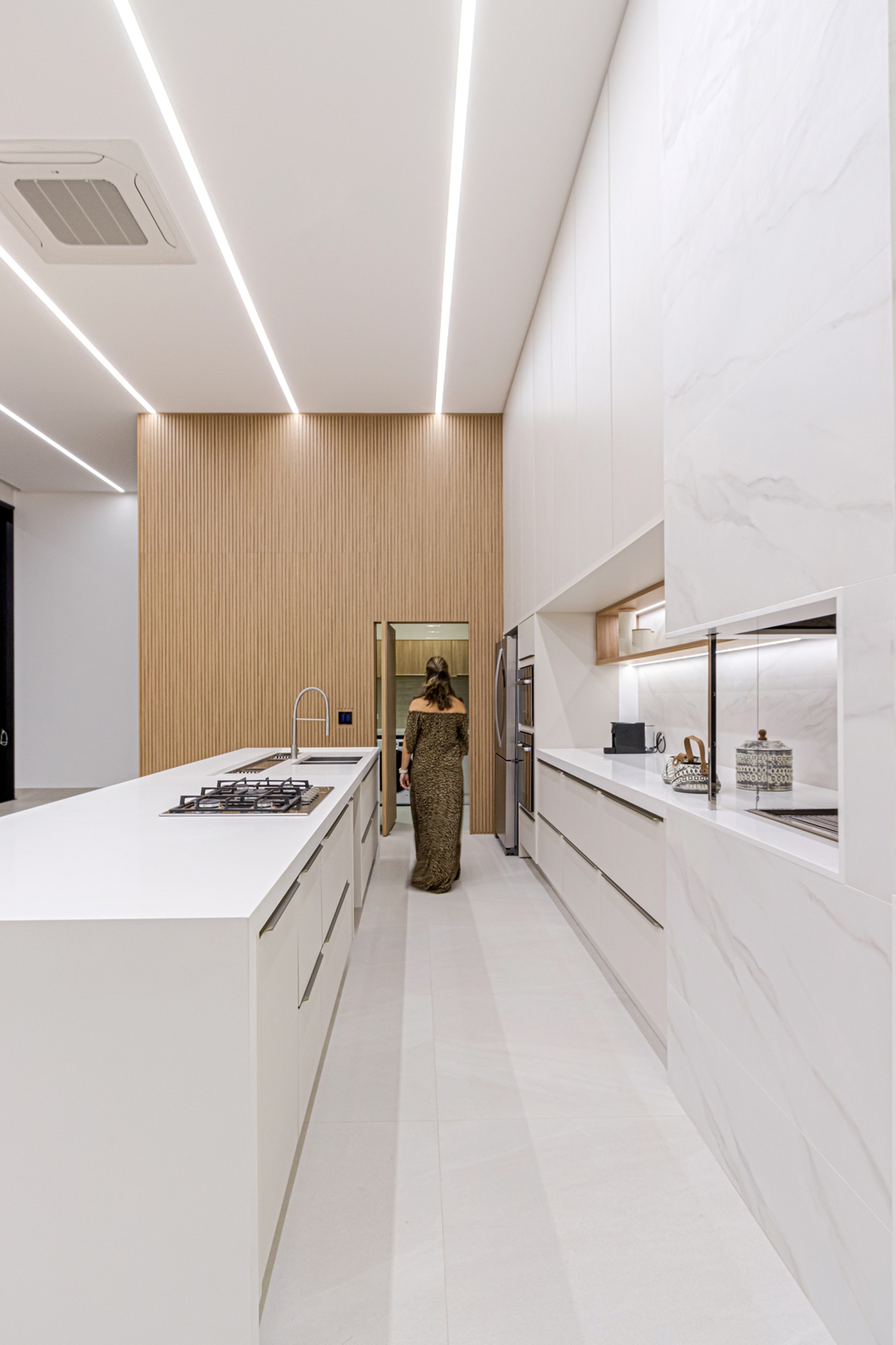 Cozinha branca com piso Ms. Barcelona e parede ripada ao fundo