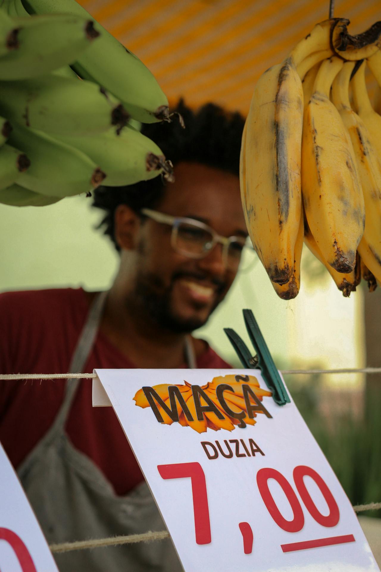 Feirante entre frutas frescas, simbolizando o consumo simples e natural que o slow living prioriza, em vez do excesso