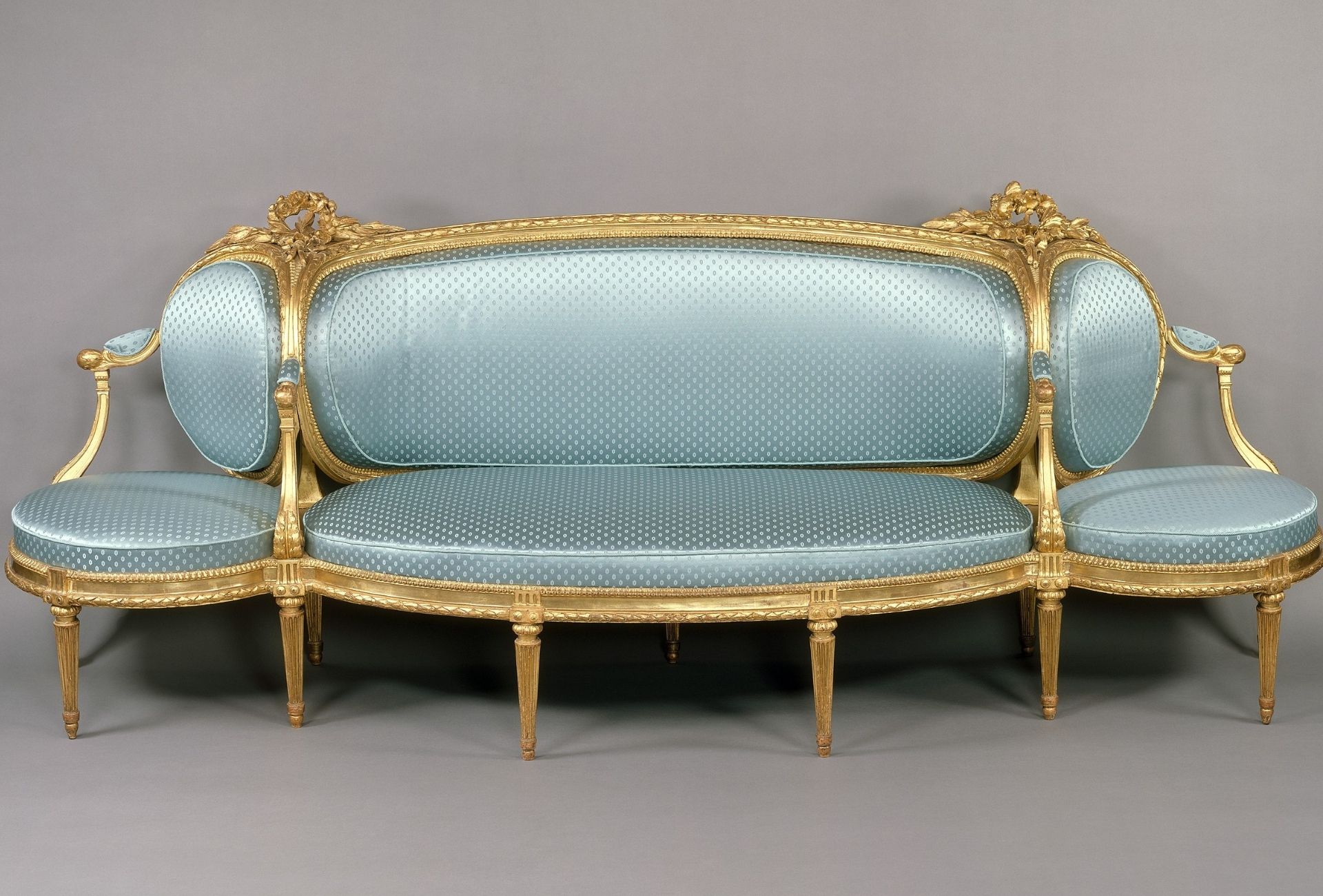Sofá em estilo francês azul com bolinhas e acabamento dourado