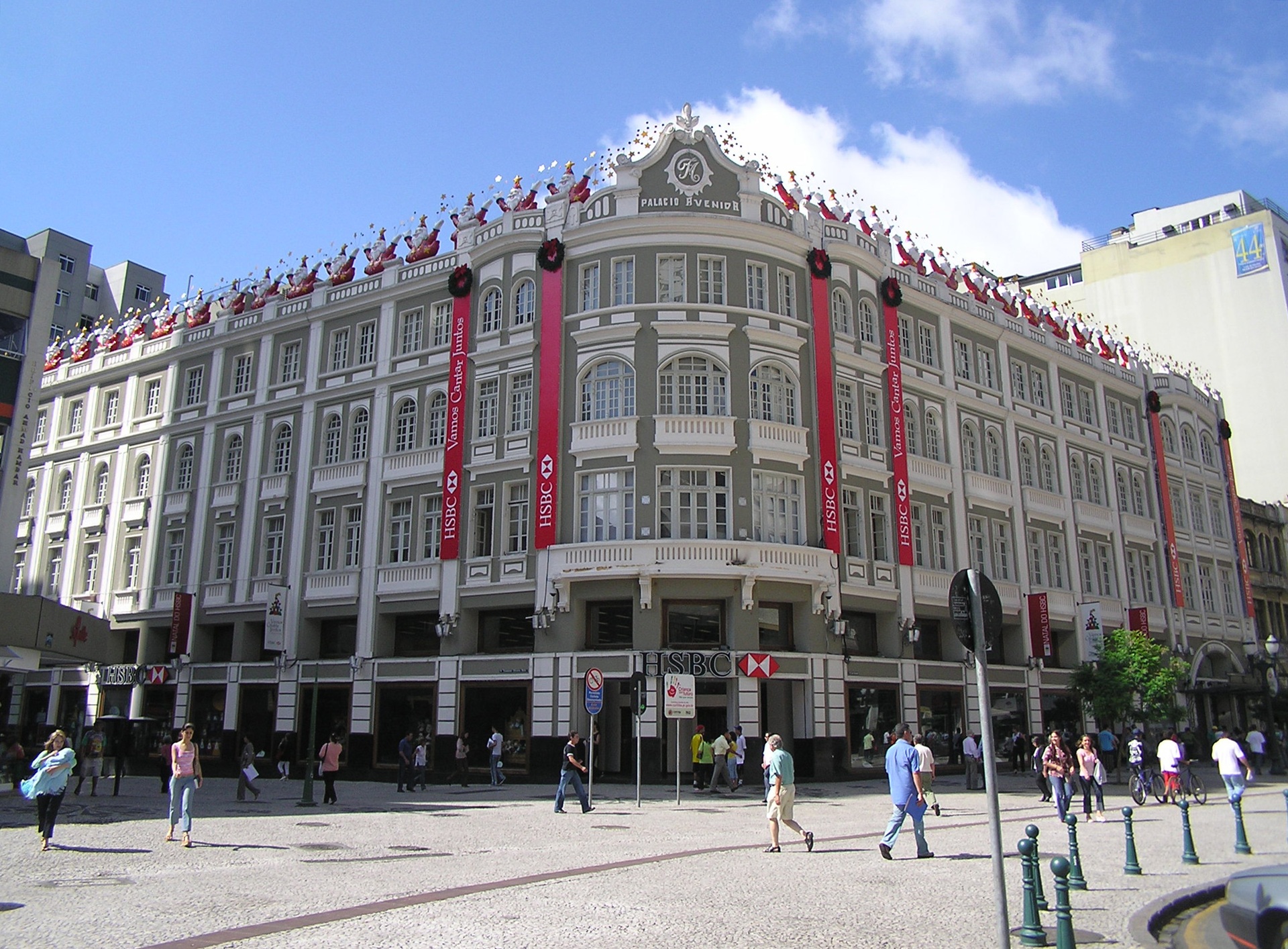 Palácio Avenida, em Curitiba, prédio histórico decorado para o Natal com público caminhando na rua