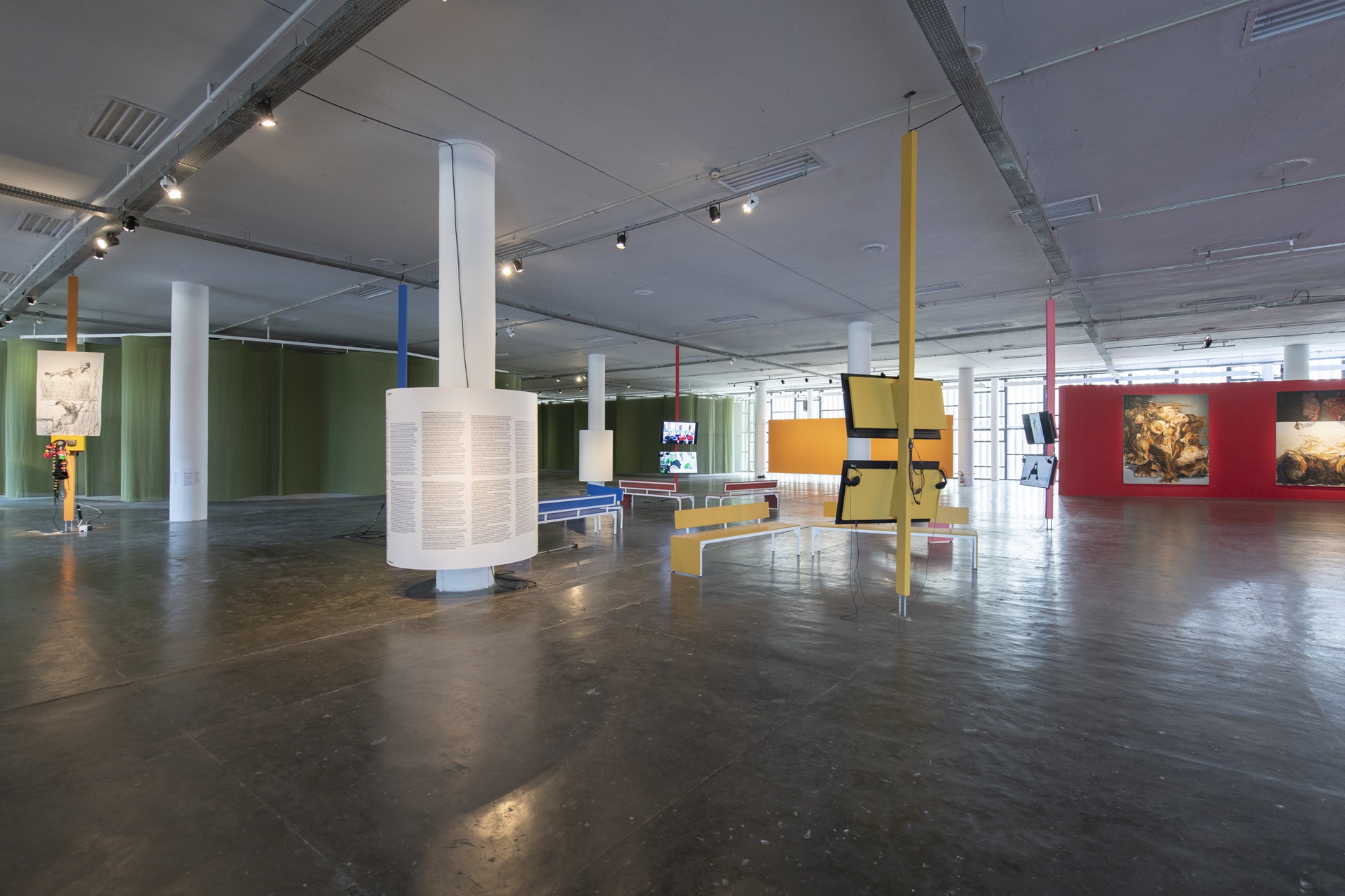 Vista interna do Pavilhão Ciccillo Matarazzo, com colunas brancas, paredes coloridas e estruturas geométricas