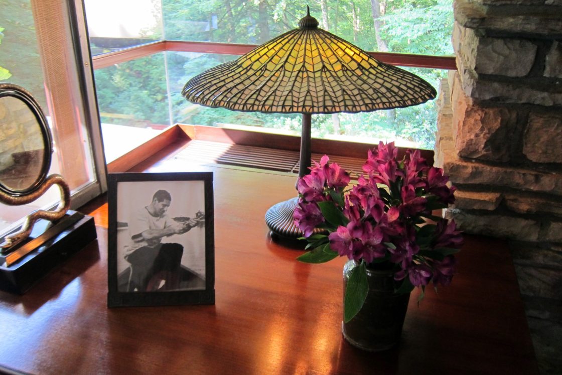 casa da cascata Vista da escrivaninha da suíte principal de Fallingwater com abajur Tiffany, moldura e flores, evidenciando o acervo da família Kaufmann