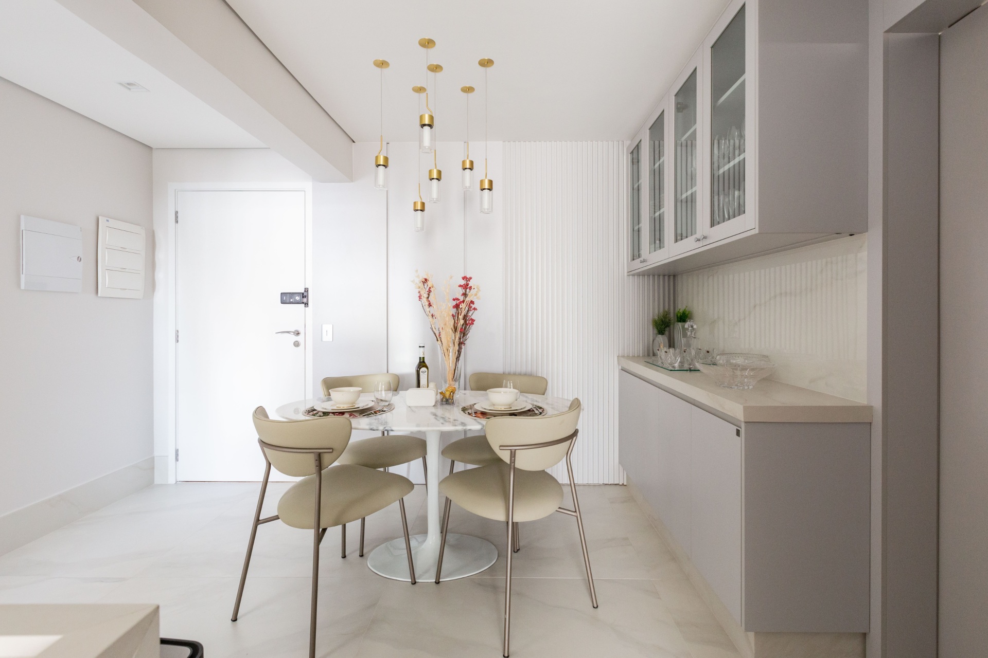 Sala de jantar com revestimento Bianco Covelano na parede atrás do aparador