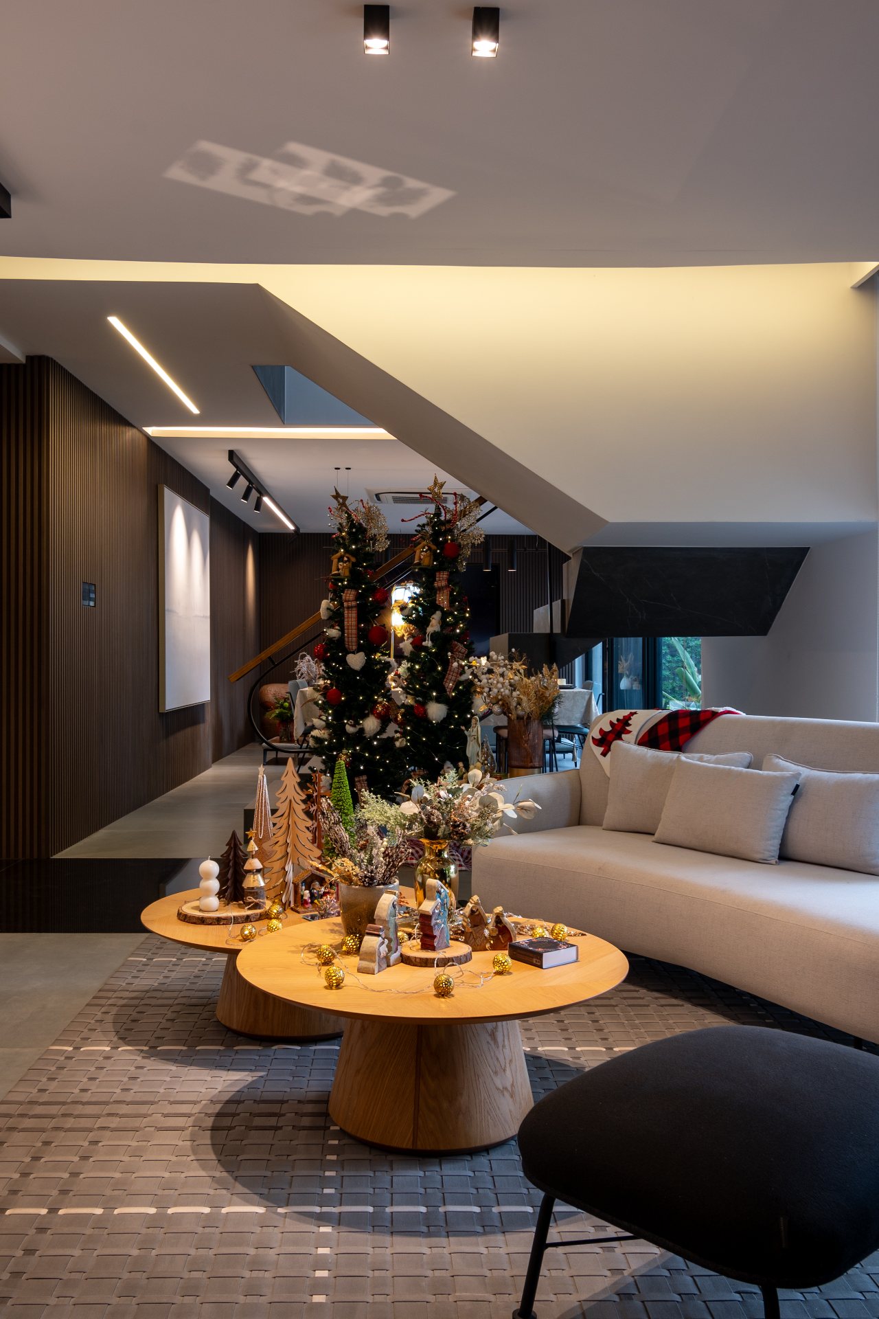 centro de mesa decorada com itens natalinos e duas árvores de Natal na sala