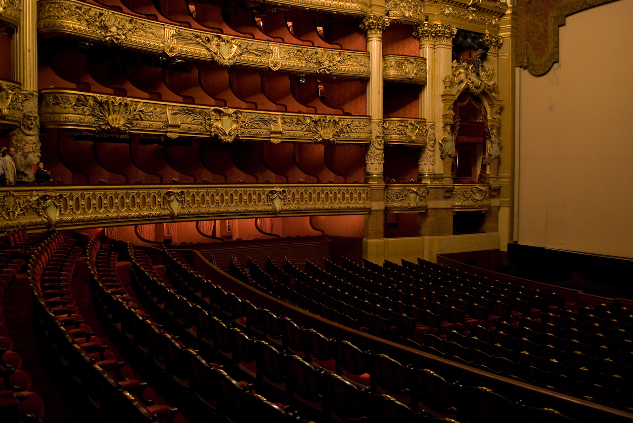 ópera garnier Vista interna da Salle de Spectacle da Ópera Garnier, em Paris, com fileiras de poltronas revestidas de veludo vermelho e camarotes ricamente decorados em dourado