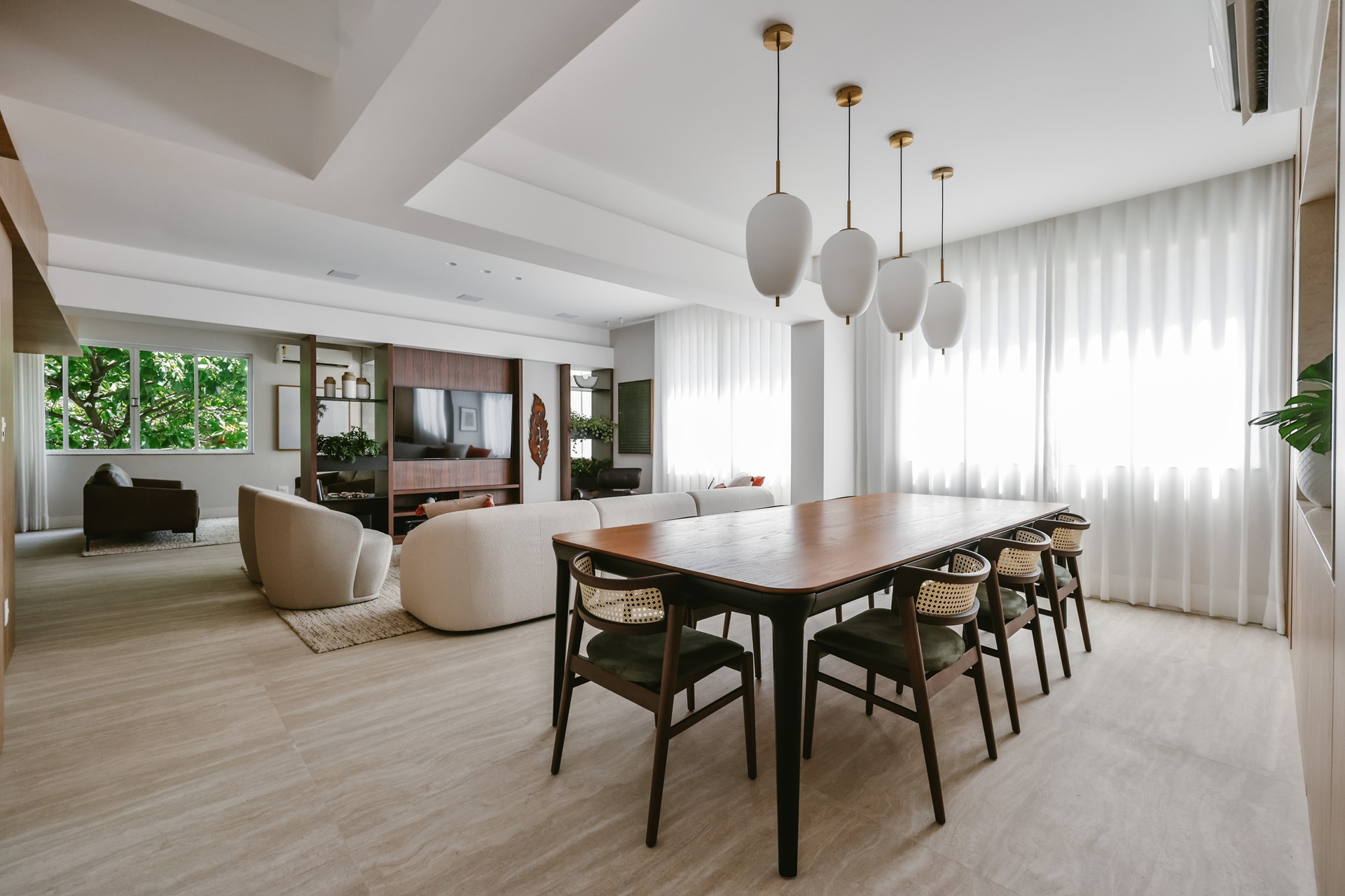 Sala de estar e de jantar integradas com piso frio que reproduz travertino
