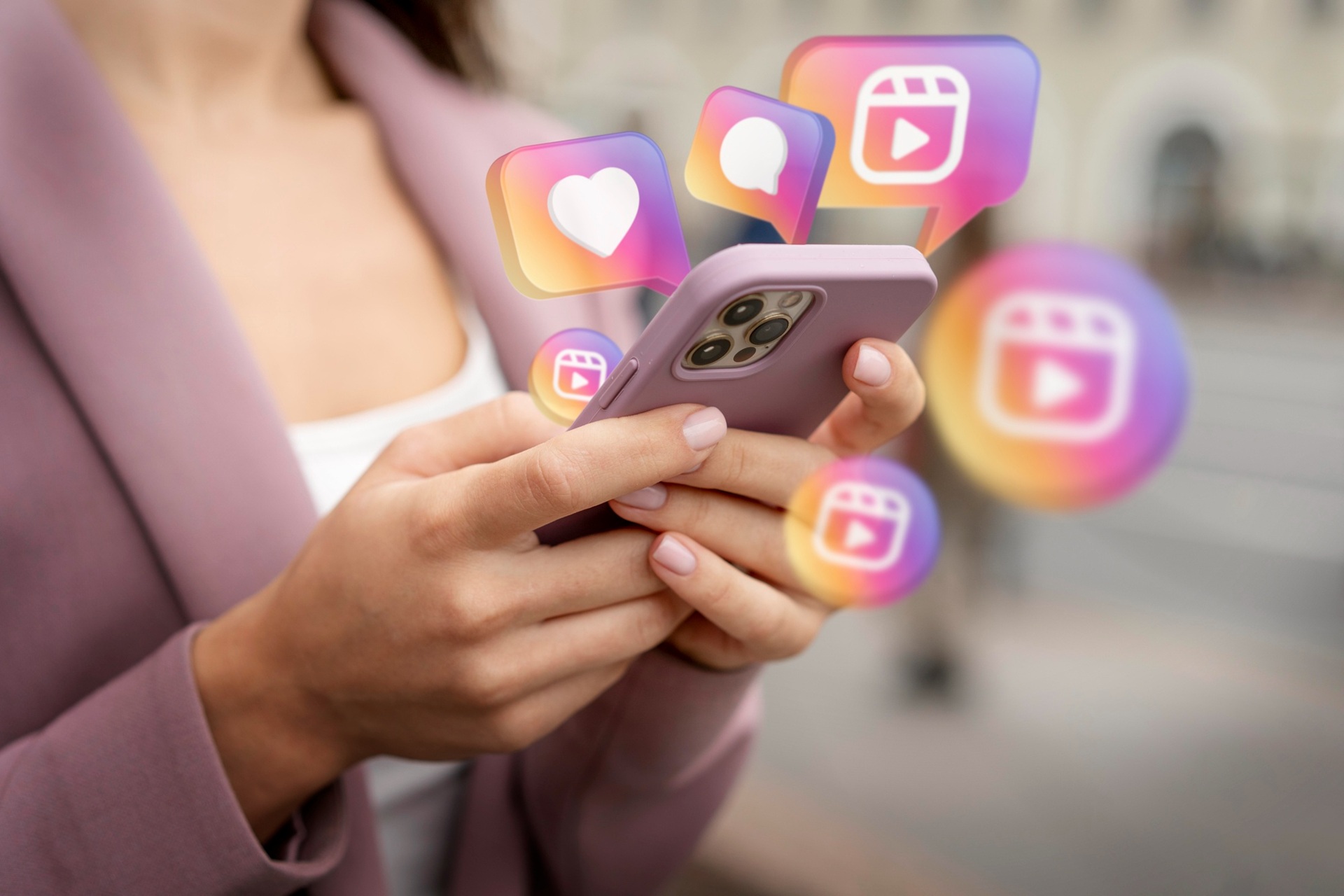 retrospectiva archtrnds 2025 Close de mãos segurando um smartphone enquanto ícones coloridos de curtidas, comentários e vídeos flutuam ao redor, simbolizando alto engajamento nas redes sociais