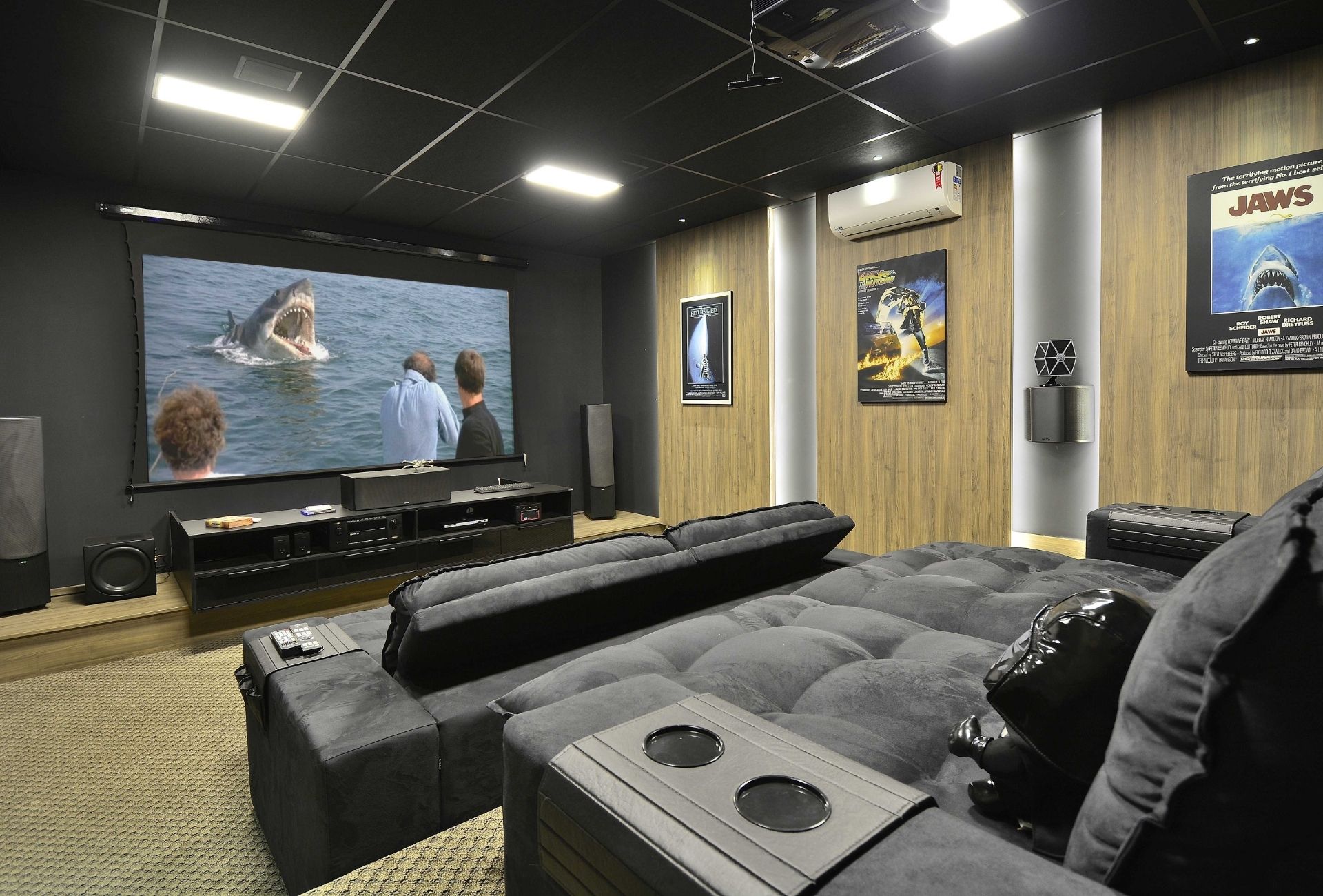 Sala de cinema dedicada com poltronas retráteis e decoração personalizada