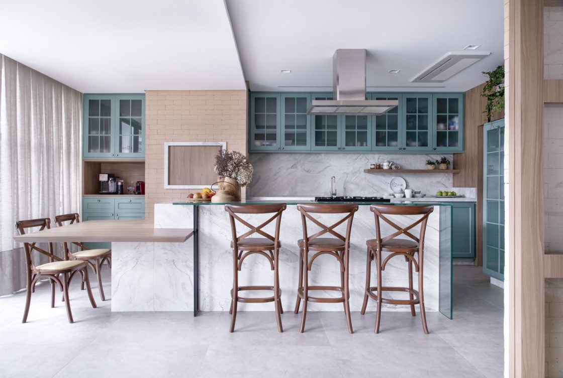 Cozinha em estilo de casa de campo, com móveis planejados azuis e ilha com banquetas de madeira