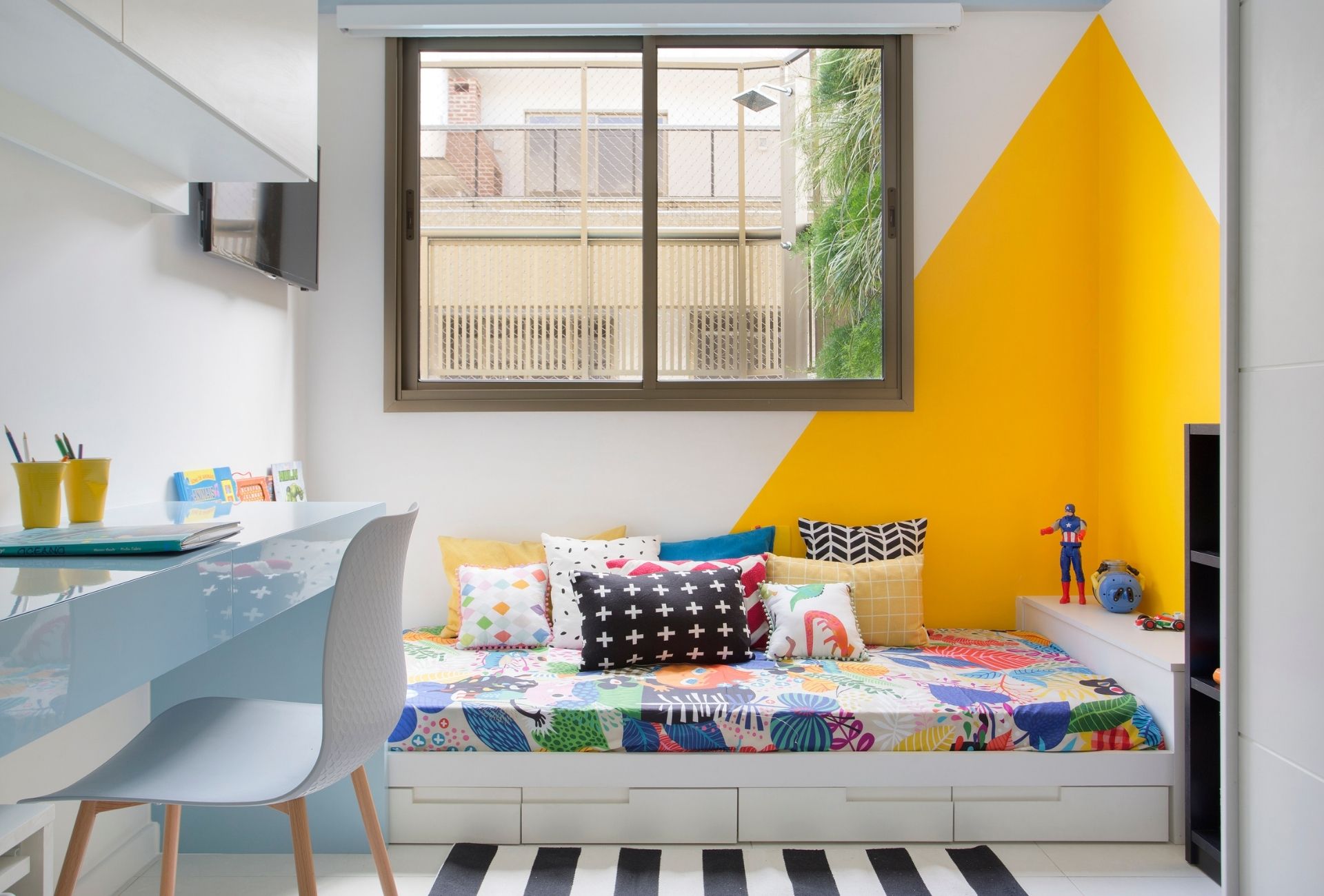 Cama montessoria em quarto infantil com base de gavetas