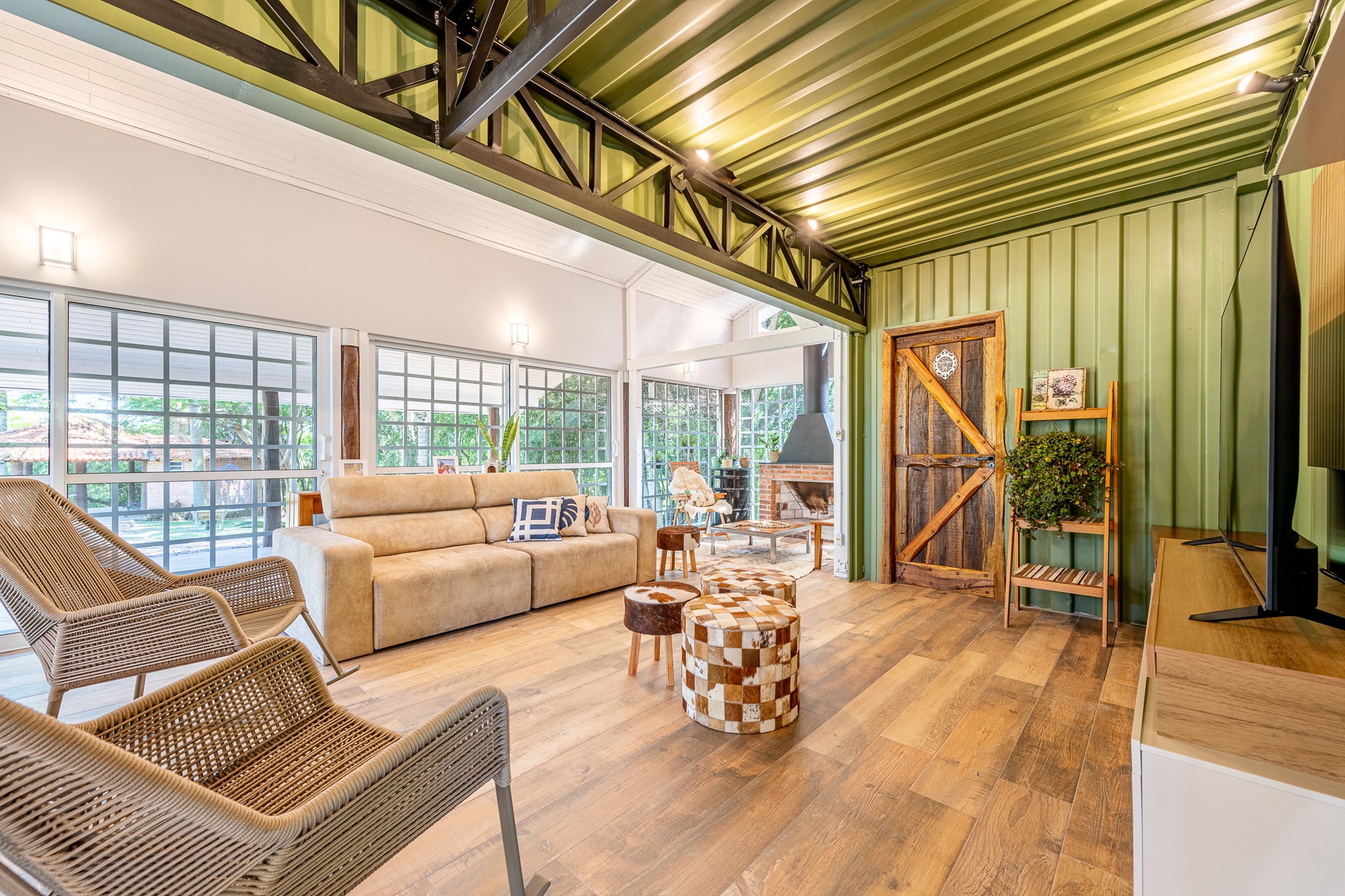 Sala de estar em estilo rústico em projeto com contêiner pintado de verde