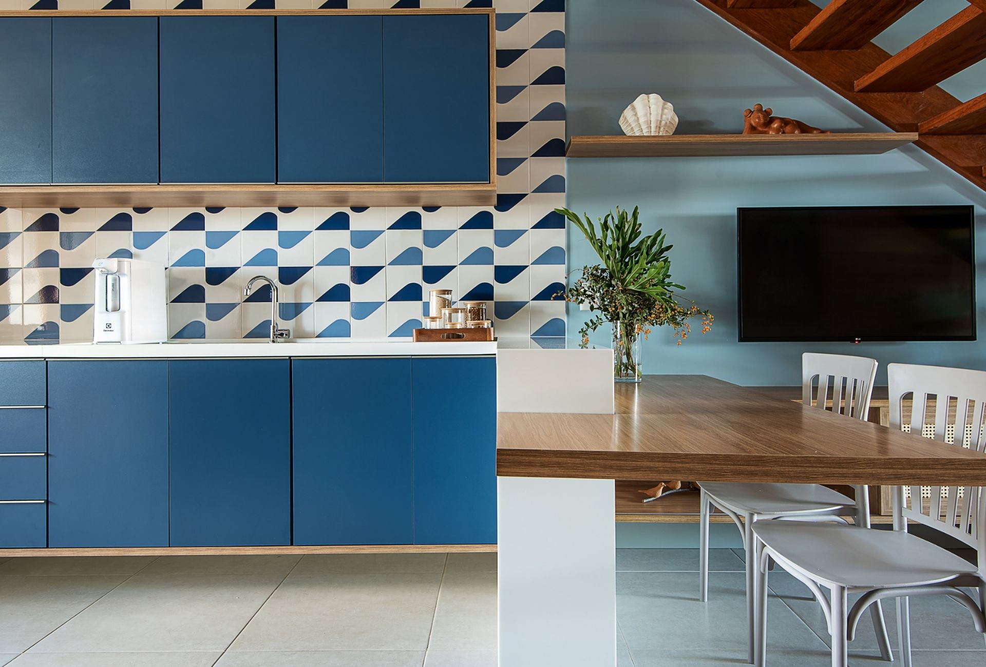 Cozinha com armários azuis e revestimentos em azul e branco