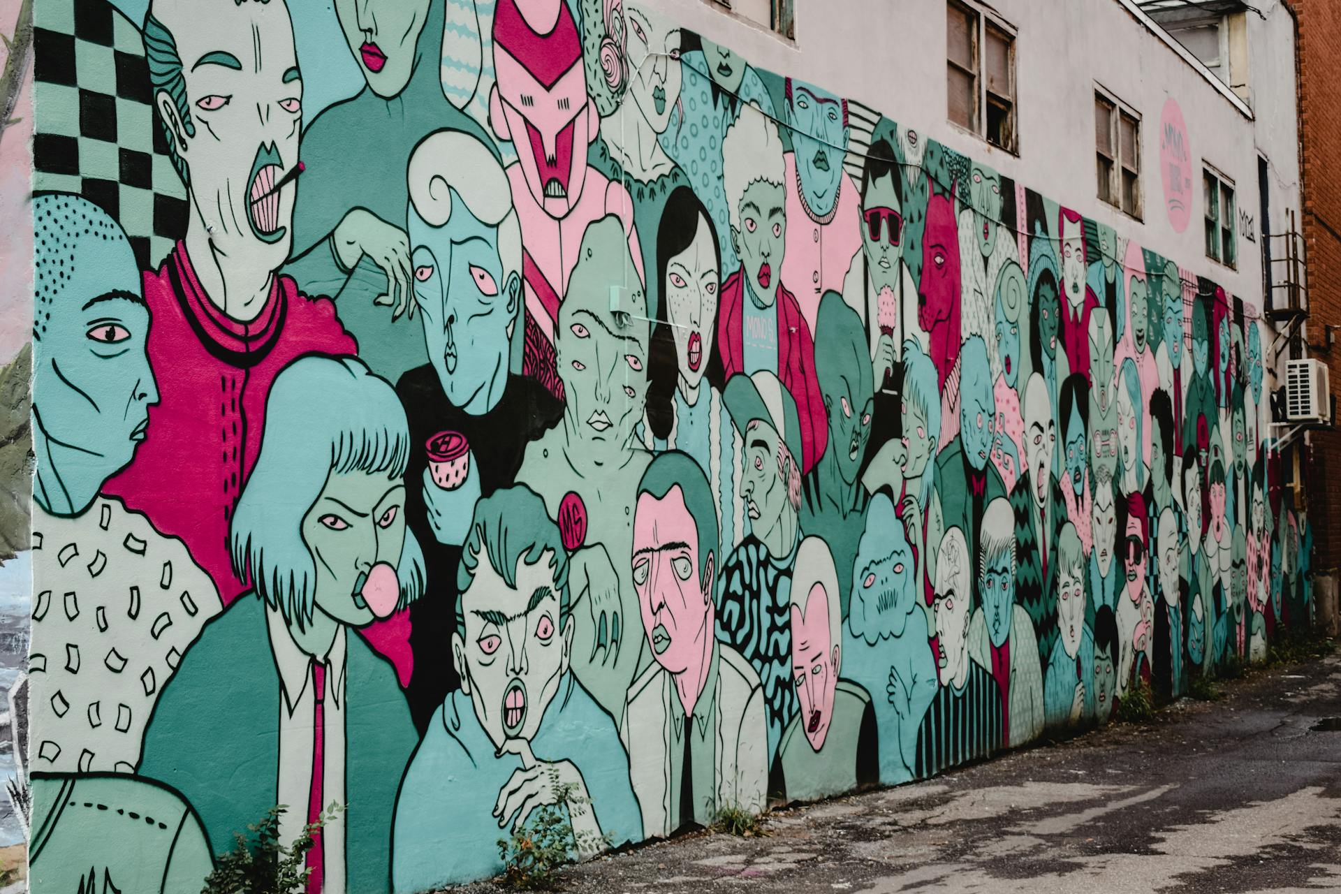street art Mural colorido ocupando toda a lateral de um prédio, com diversas figuras humanas em tons de azul, rosa e preto