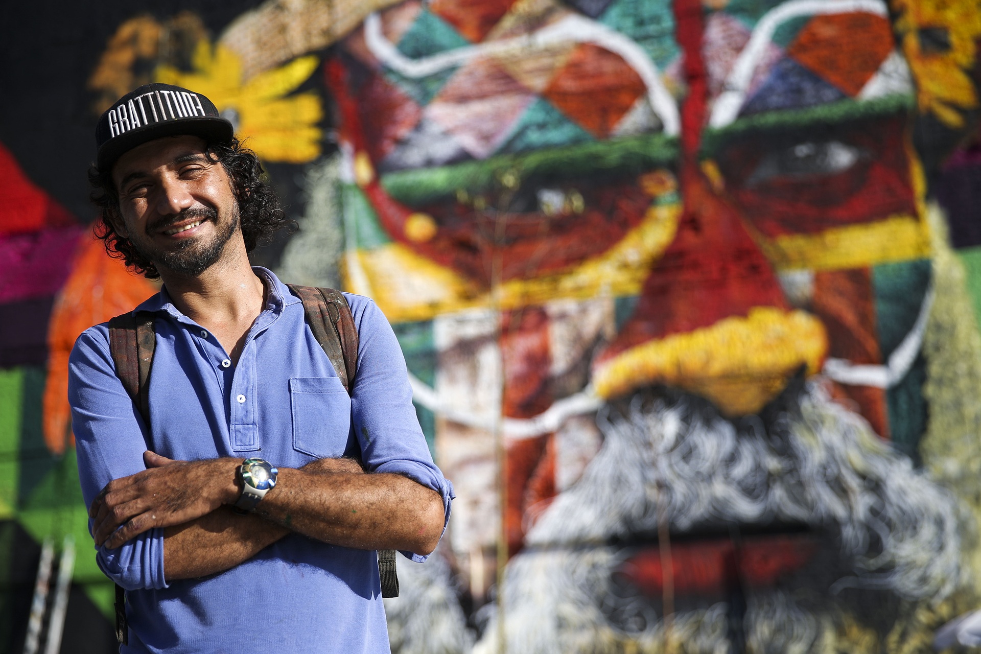 street art Eduardo Kobra tendo ao fundo seu mural “ Somos todos um” no Boulevard Olímpico na região do porto maravilha