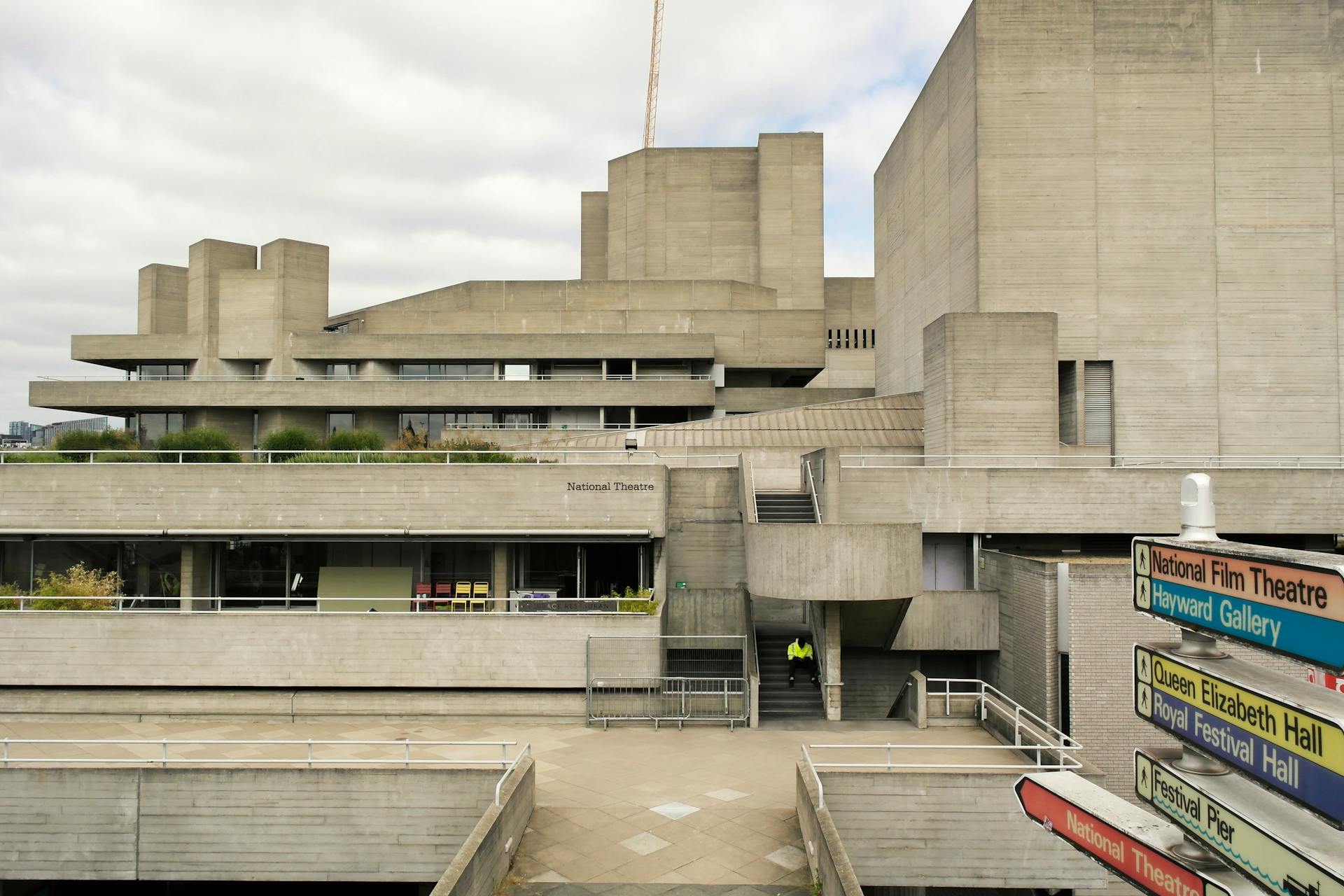 Vista do Royal National Theatre em Londres, com estrutura em concreto aparente e formas geométricas típicas do estilo brutalista, sob céu nublado