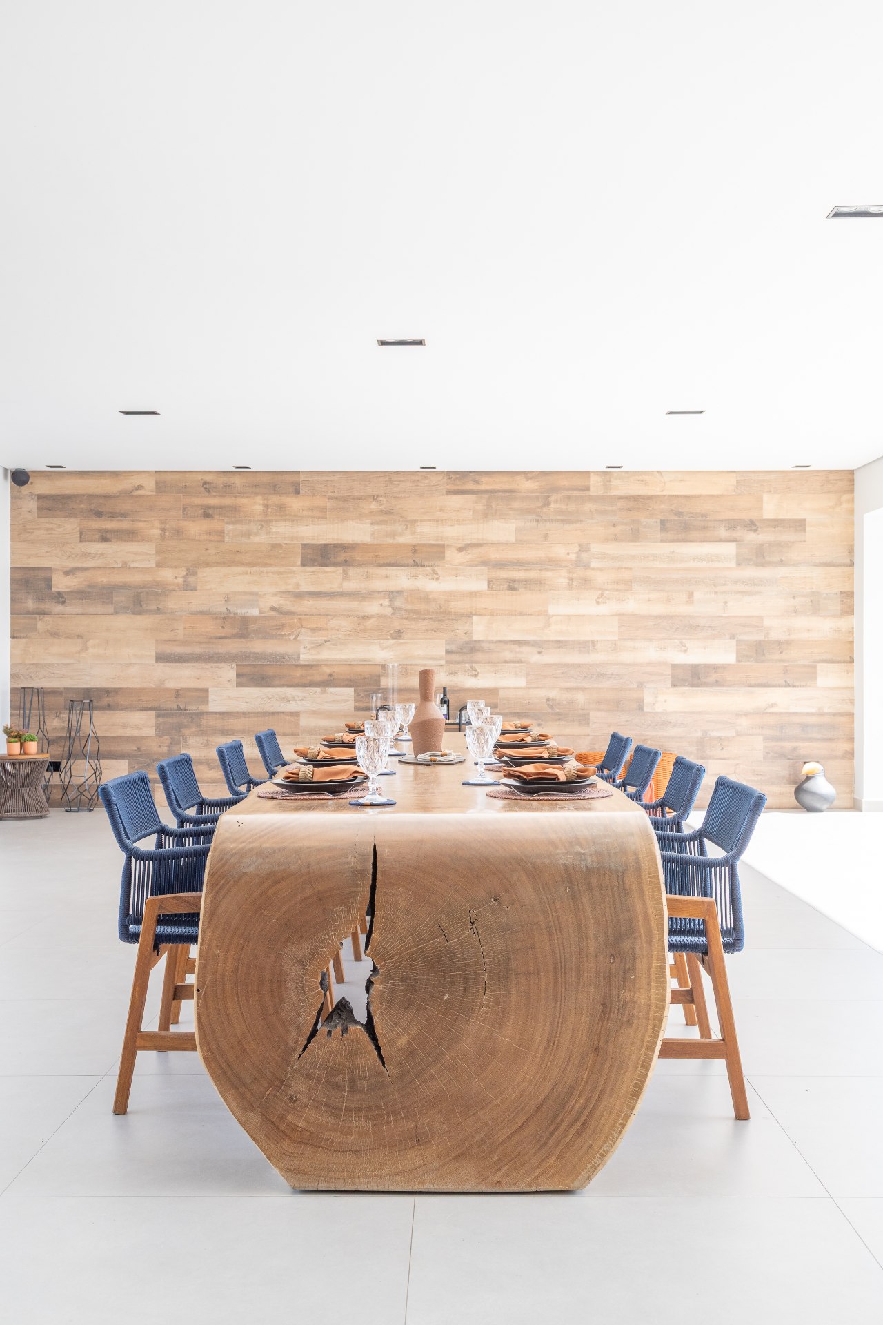 sala de jantar com madeira na mesa e na parede e com cadeiras azul marinho