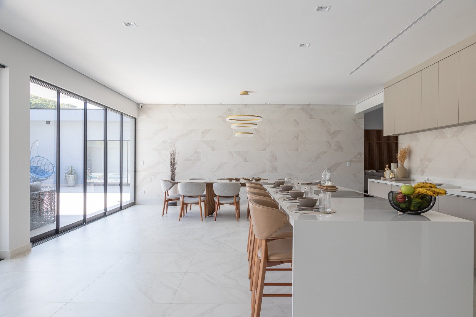 sala de jantar e cozinha com tons neutros na parede, piso e bancada