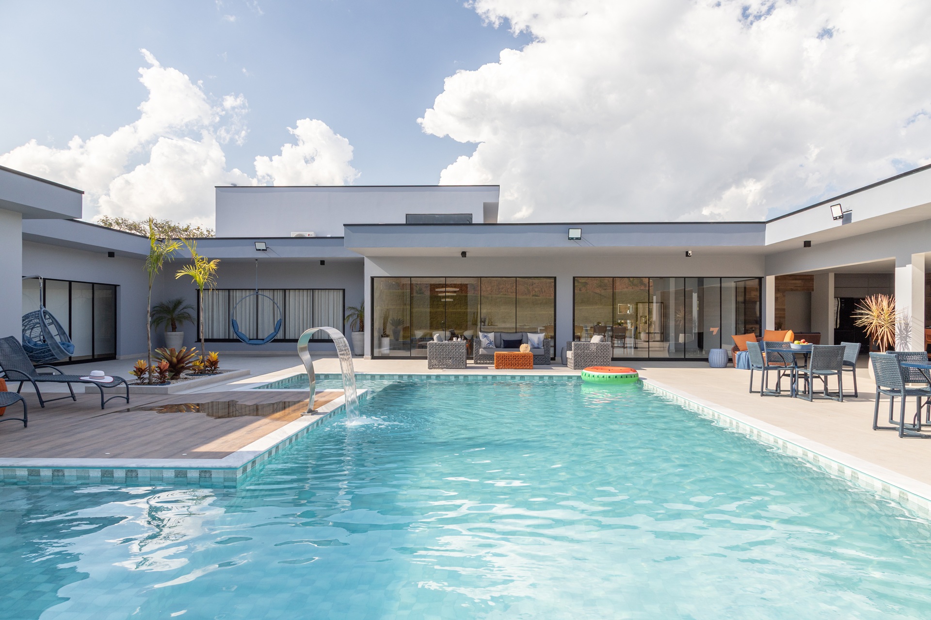 Área externa de casa contemporânea em tons neutros e com piscina em alvenaria