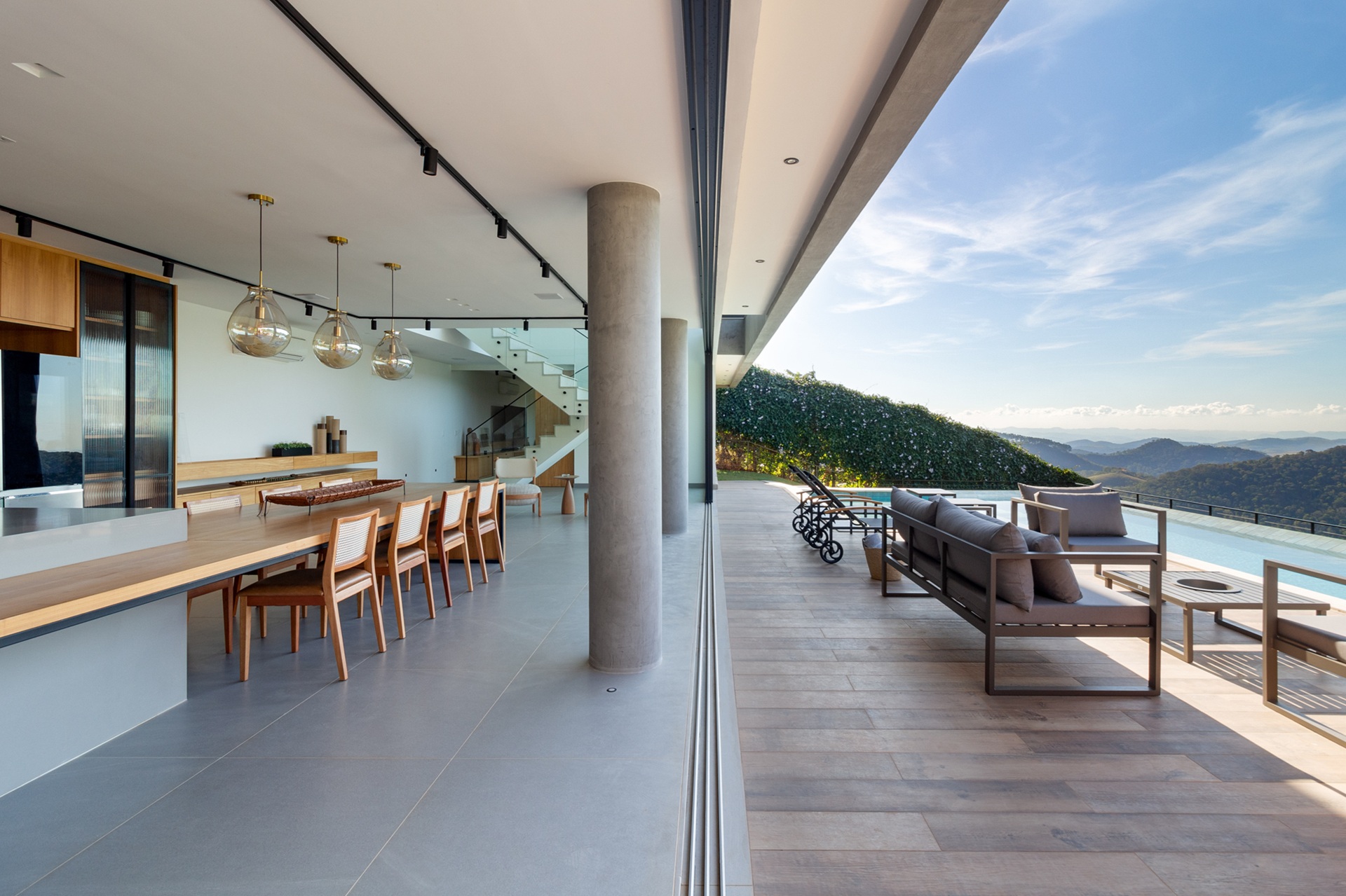 Área externa com piscina e piso amadeirado integrada à cozinha gourmet