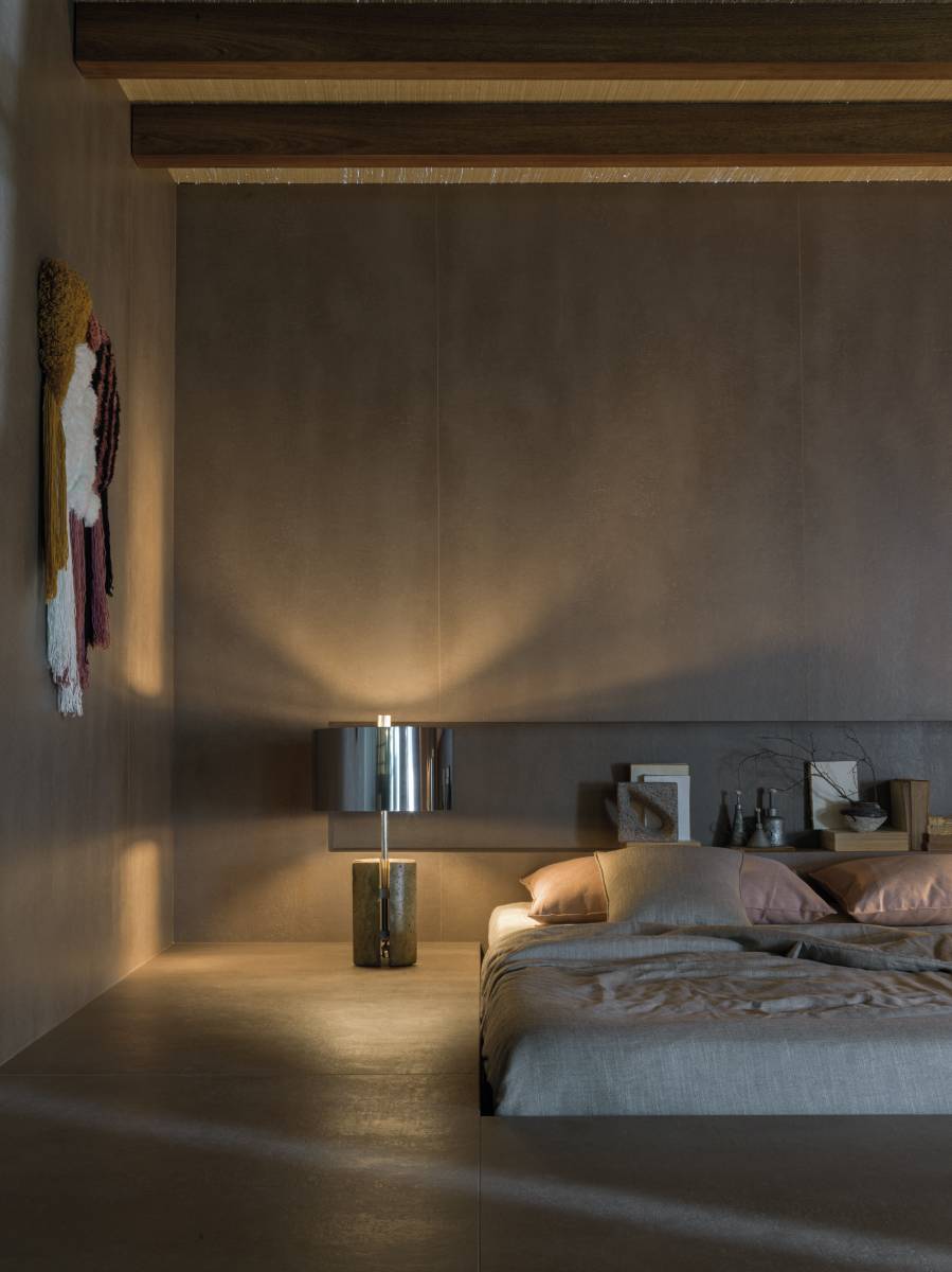 Quarto em estilo industrial com tapeçaria de parede ao lado de cama de casal