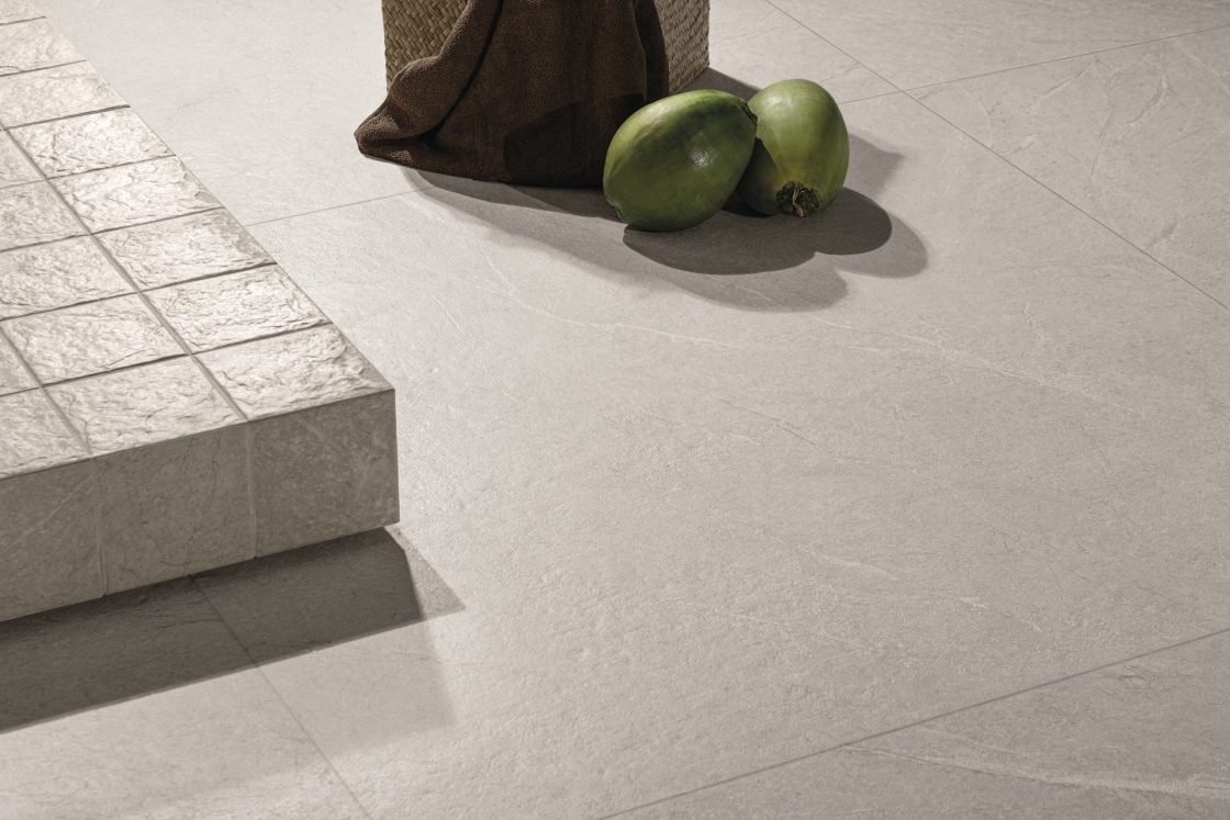 Detalhe de piso com revestimento Apalaches em tom claro e dois cocos verdes