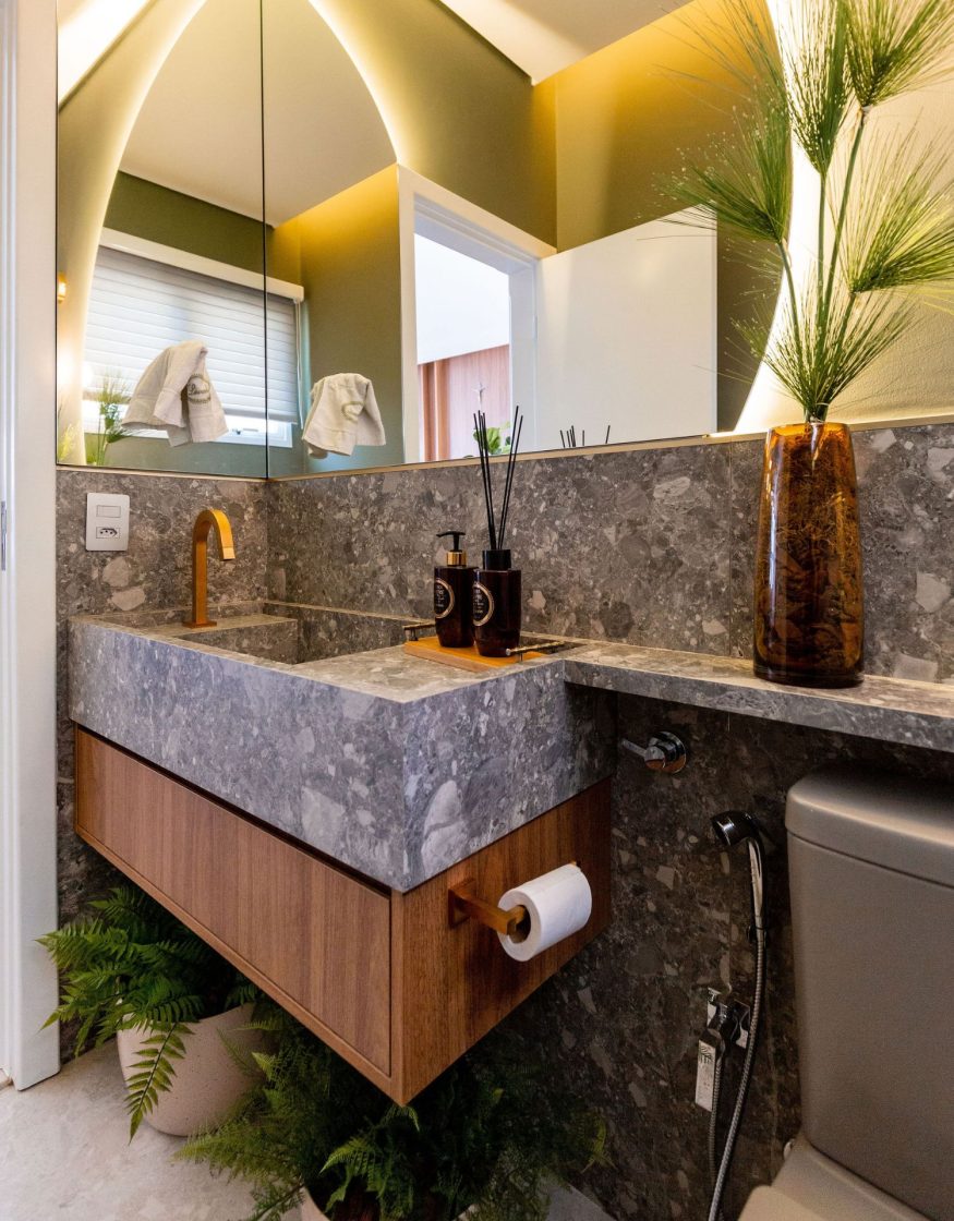 Close-up de bancada de lavabo com cuba esculpida, ambas revestidas em porcelanato cinza