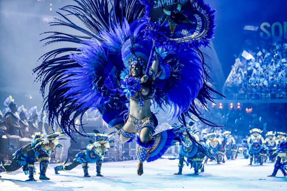 Cunhã-poranga do Boi Caprichoso se apresenta no Bumbódromo com fantasia azul repleta de penas e elementos inspirados na cultura amazônica