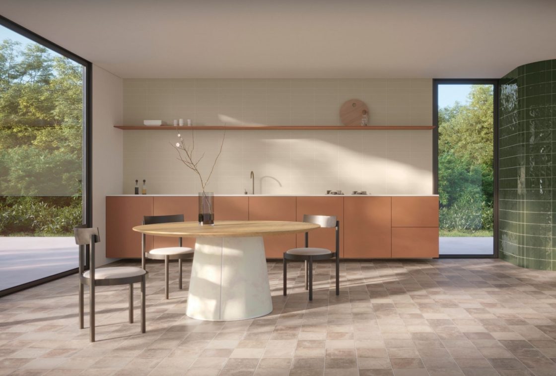 Cozinha minimalista e contemporânea com forte entrada de luz solar lateral. O piso é revestido com porcelanato de textura cinza destonalizada imitando pedra natural