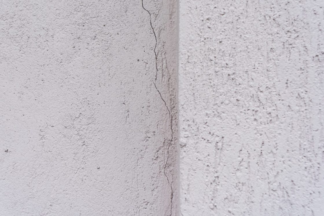 Quina de parede pintada de branco com fissura