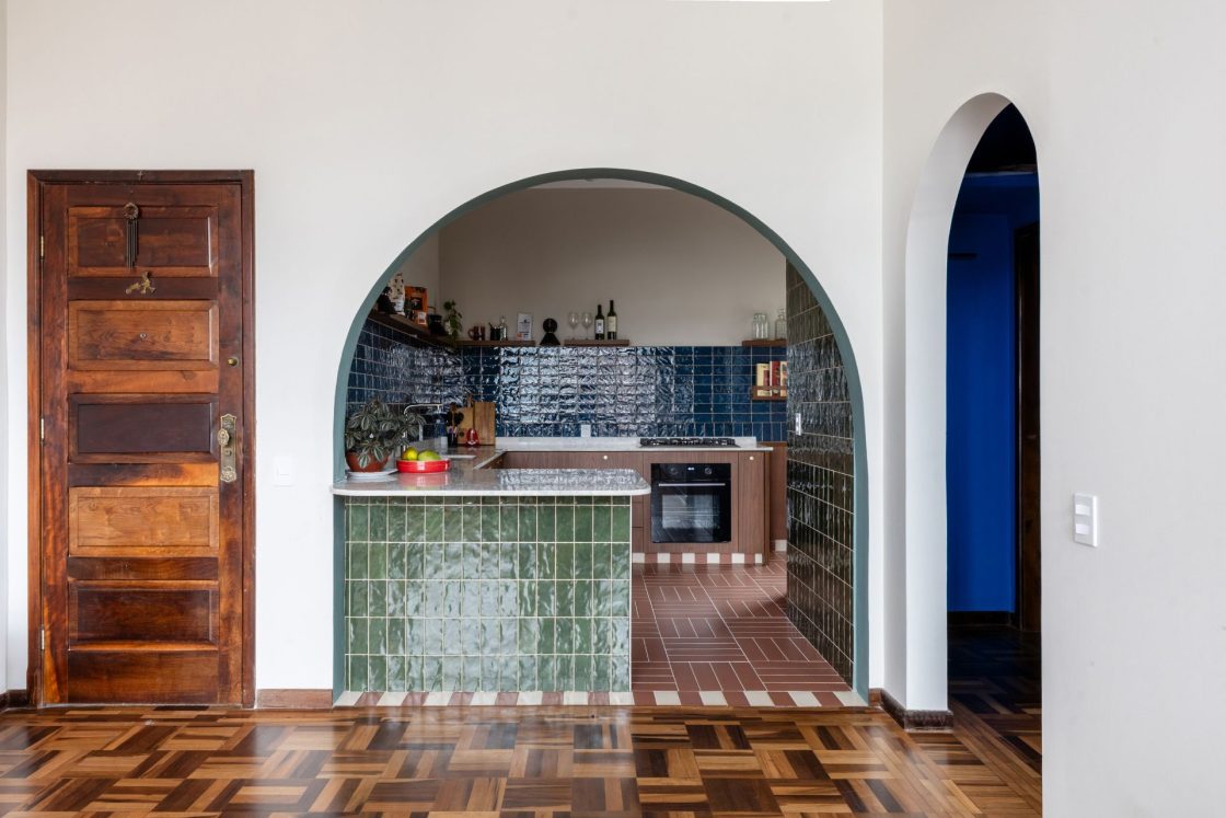 Ambiente com piso de taco com visão para cozinha integrada que mistura revestimentos Portobello nas cores verde, terracota e azul