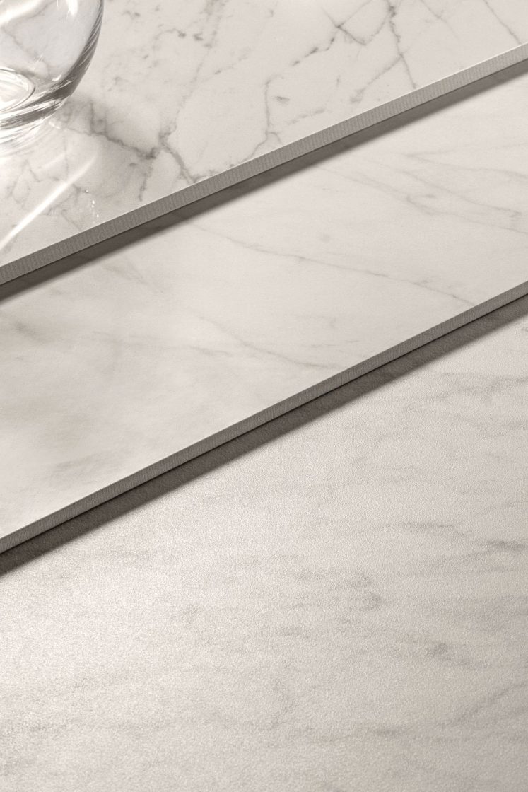 Detalhe de três revestimentos que reproduzem mármore branco, mas com texturas diferentes na superfície