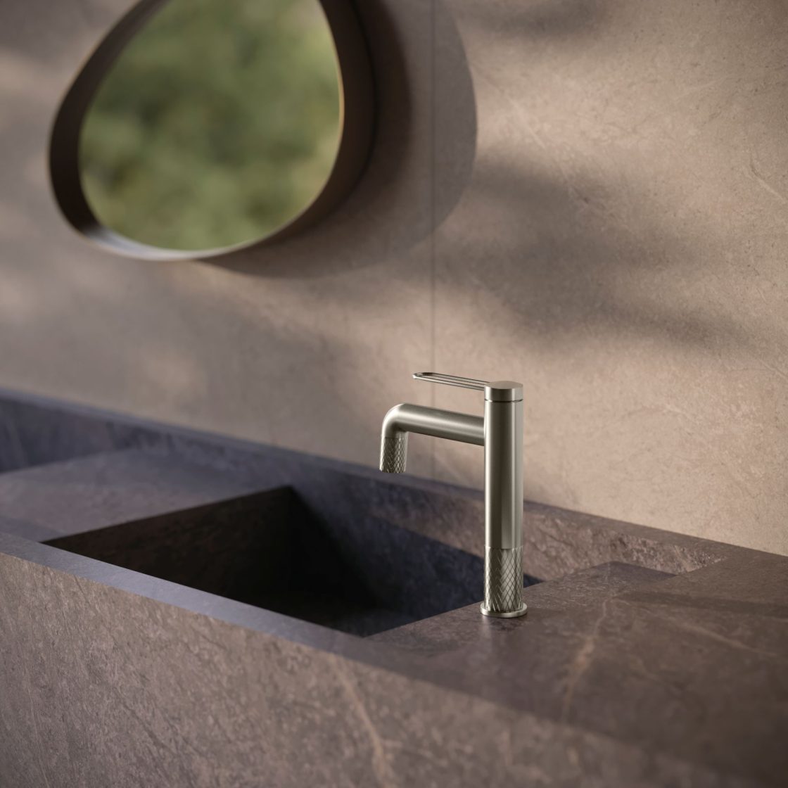 Detalhe de cuba esculpida, em posição lateral, em bancada de porcelanato que reproduz pedra grafite