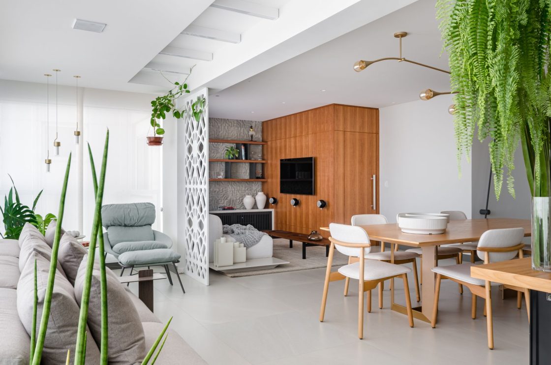 Living integrado à sala de estar e de jantar, com biombo branco ajudando a delimitar ambiente