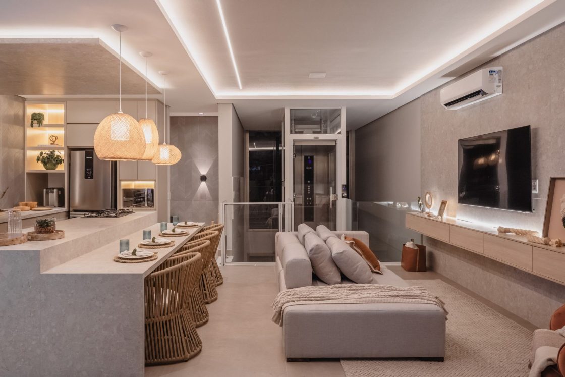 Sala de estar integrada a cozinha com ilha, em tons neutros e claros