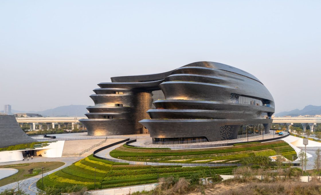 Museu com formas orgânicas que lembram navios em fachada prateada que reflete a luz do sol